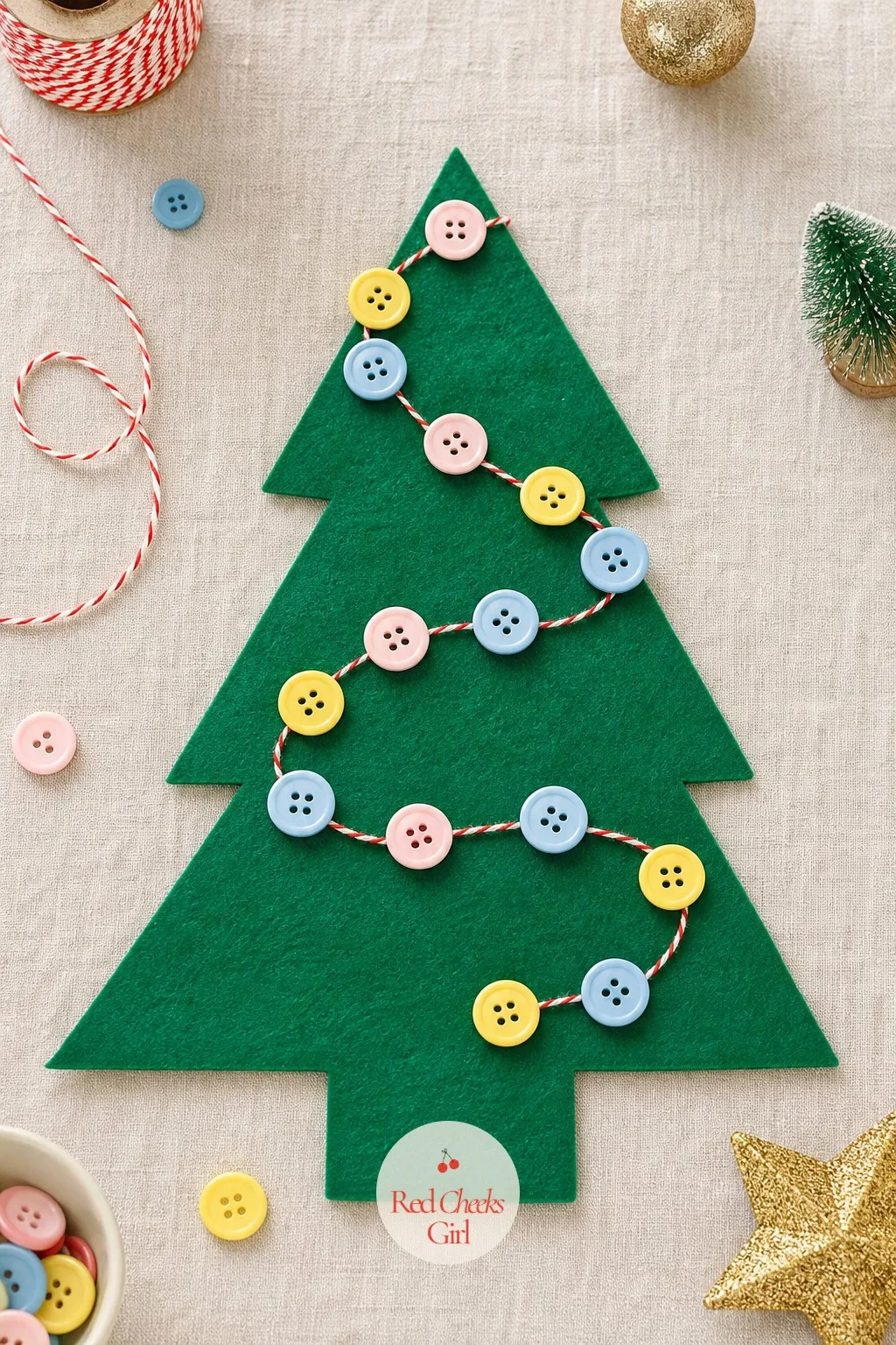 Button Garland Tree — An emerald felt cutout becomes the base, and a garland of threaded buttons in blush, butter yellow and sky blue winds across it in loose