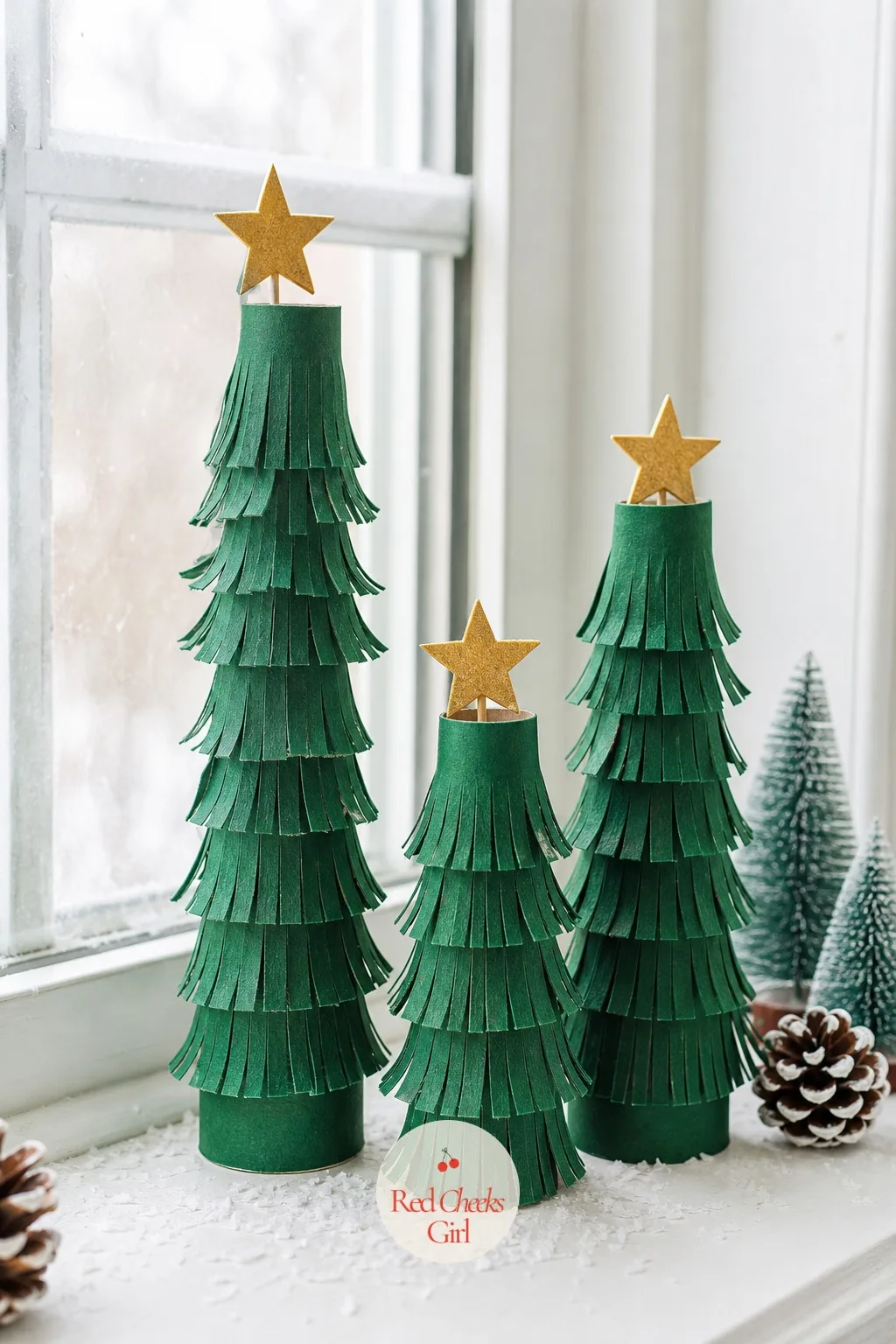 Toilet Paper Roll Tree Trio — Three cardboard tubes, saved rather than bought, get wrapped in forest green paper and snipped at the top edge to fringe out like