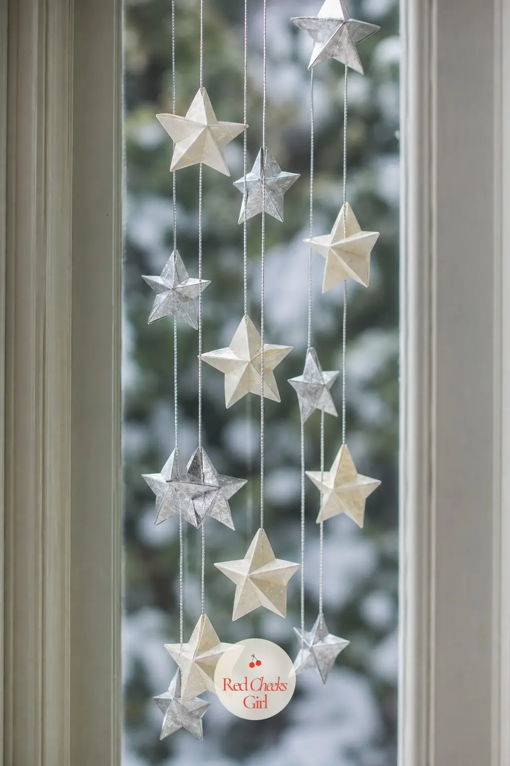 A Cluster of Small Origami Stars Strung at Different Heights Down a Tall Window — Instead of one big star, fold ten small ones in ivory and silver and hang