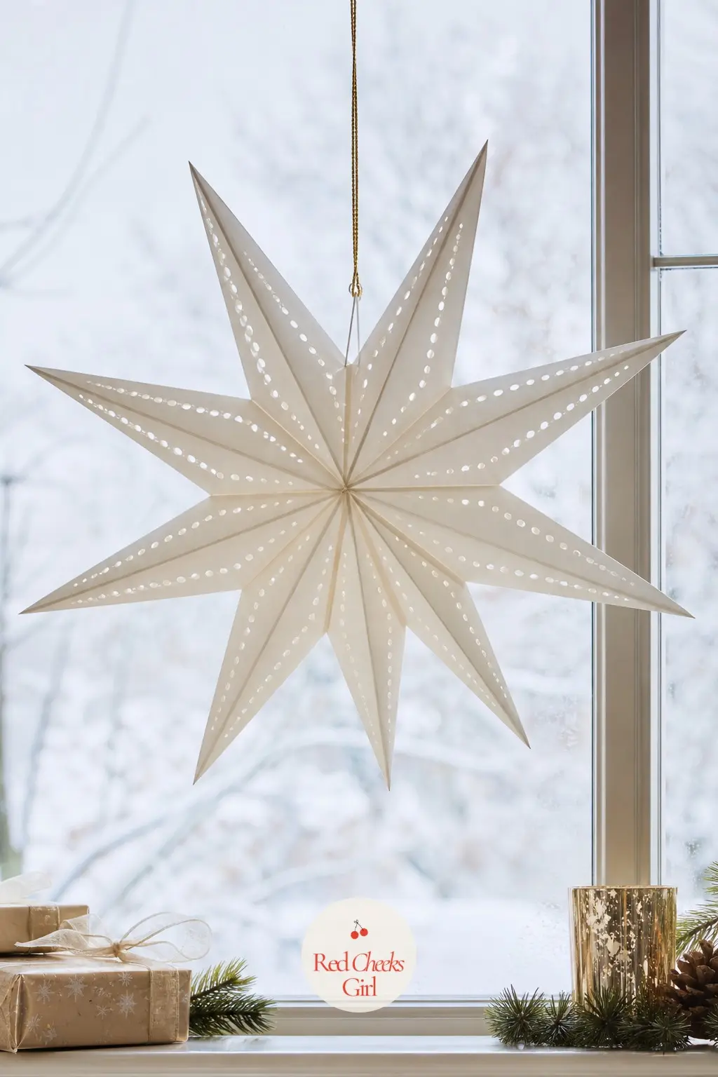 A Large Folded Paper Star Suspended at the Center of a Picture Window — One oversized star, hung dead centre on fine thread, has more presence than a dozen