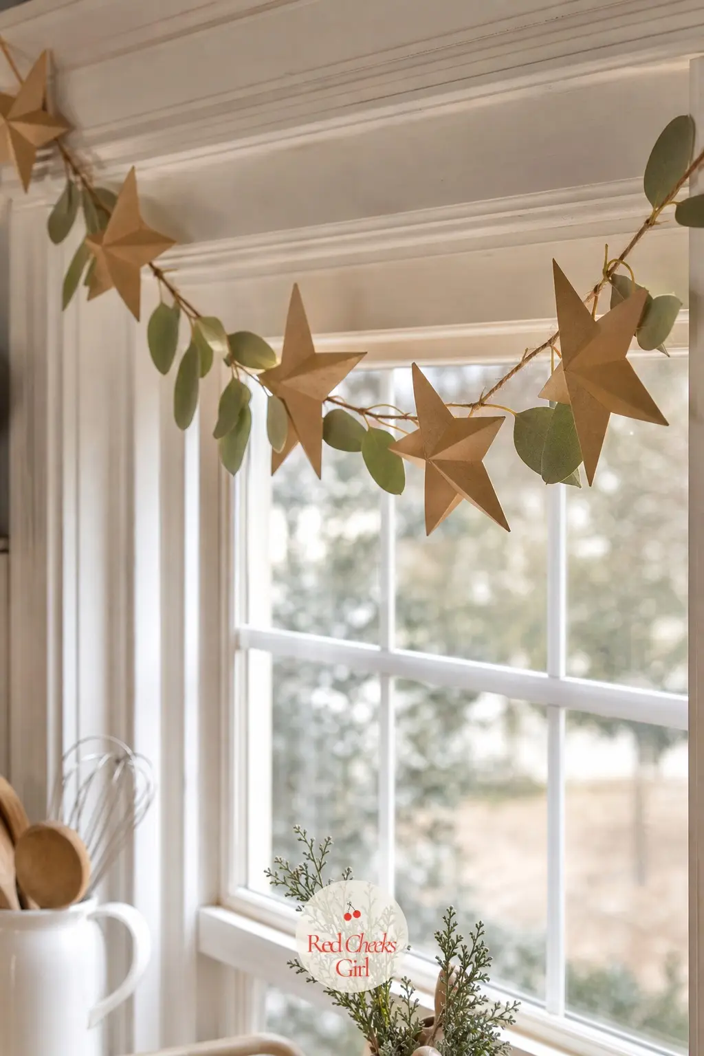 Paper Star Garland Looped Along the Top of a Kitchen Window — A simple garland of small paper stars threaded on cotton twine along the top of a kitchen window