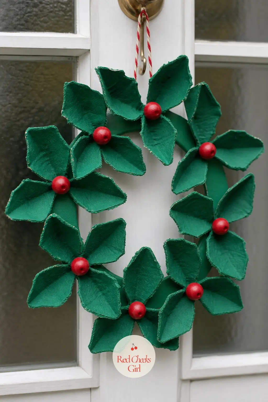 Egg Carton Holly Wreath — Cut the cups from a cardboard egg carton, trim each one into a leaf point, and paint them deep green. Christmas wreath crafts for kids