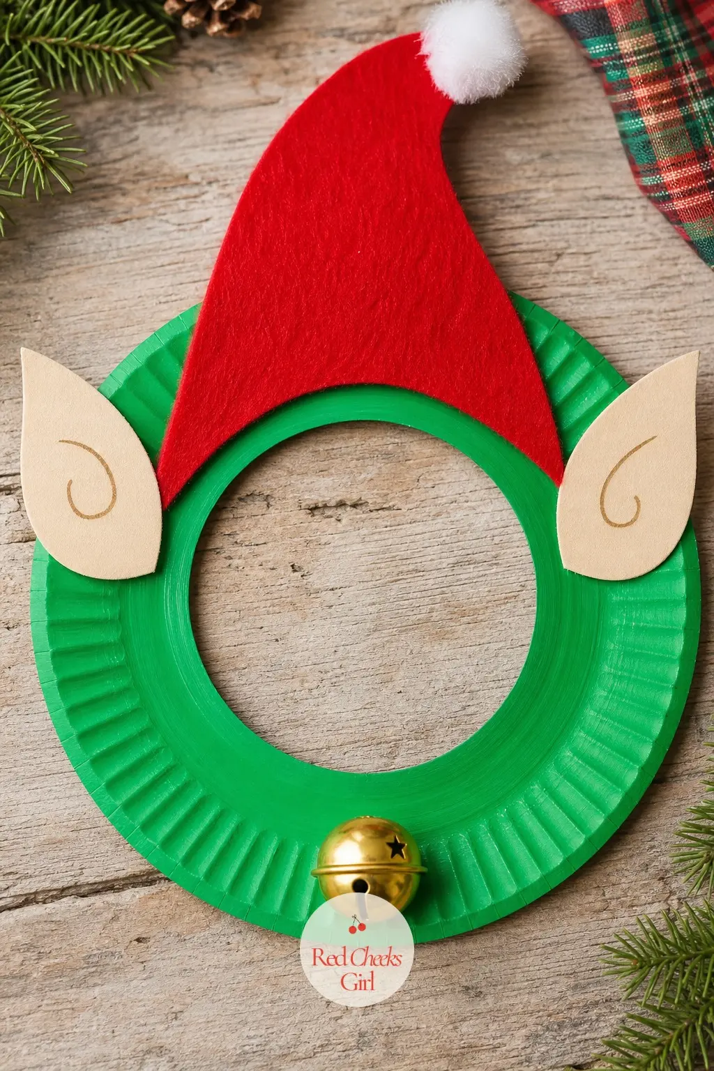 Elf Paper Plate Wreath — Paint the ring bright green, add a red felt triangle hat at the top with a cotton ball pom on its tip, then glue two cream paper ovals