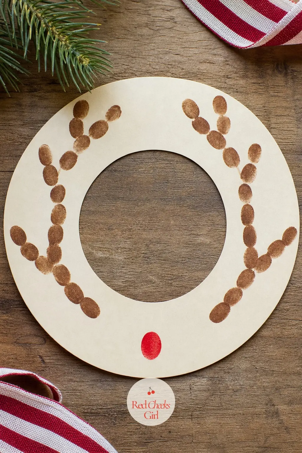 Fingerprint Reindeer Antler Wreath — On a cream paper ring, use a brown stamp pad to press fingerprints in branching lines that fan out like antlers at six or