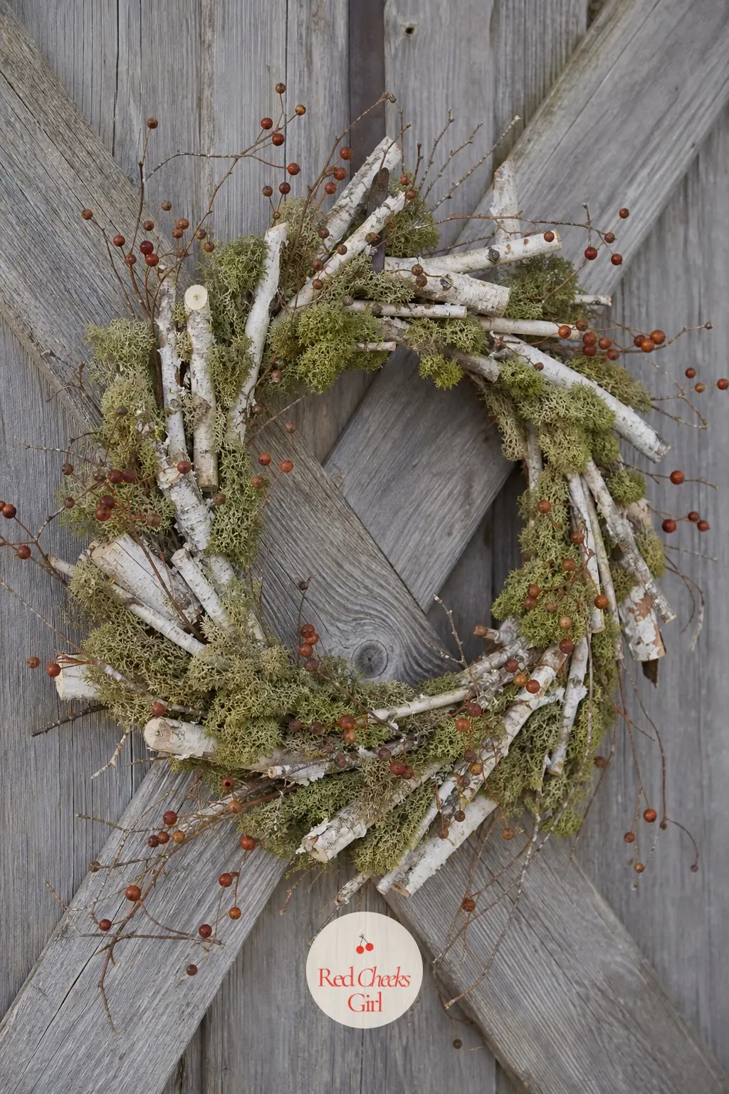 Birch Bark and Moss Wreath — White birch twigs bent into a loose ring, patches of moss green reindeer moss, a few rust-coloured berries tucked in. Christmas