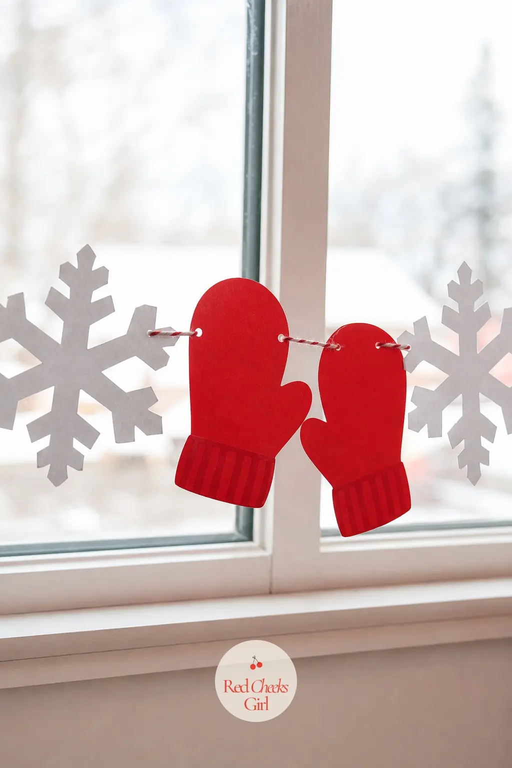 A Mitten and Snowflake Paper Chain Looped Across the Window — Alternate red paper mittens with white paper snowflakes along a length of twine strung across the