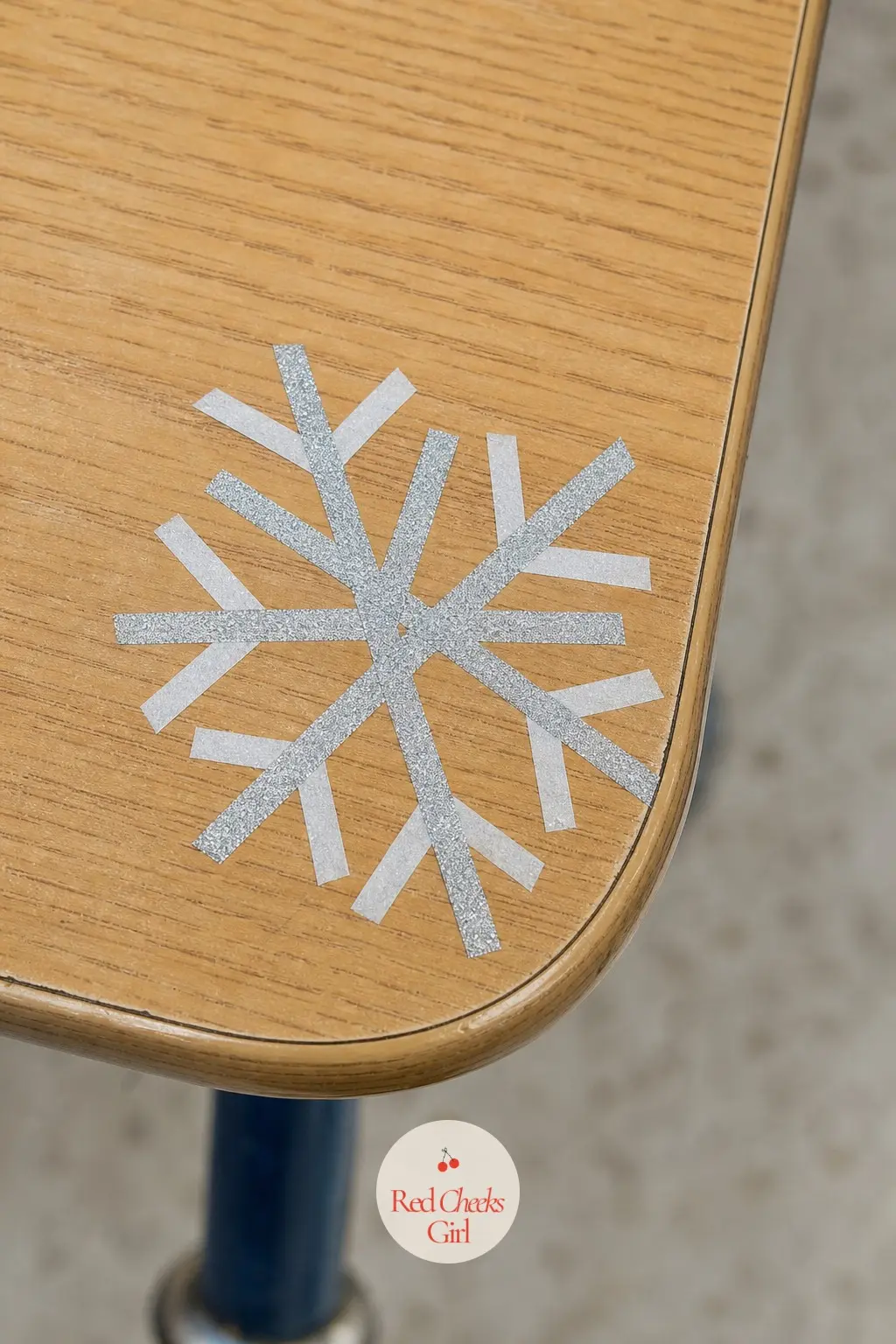 A Washi Tape Snowflake Marking Each Desk Corner — Press a simple snowflake shape onto the corner of every desk using thin strips of silver and white washi