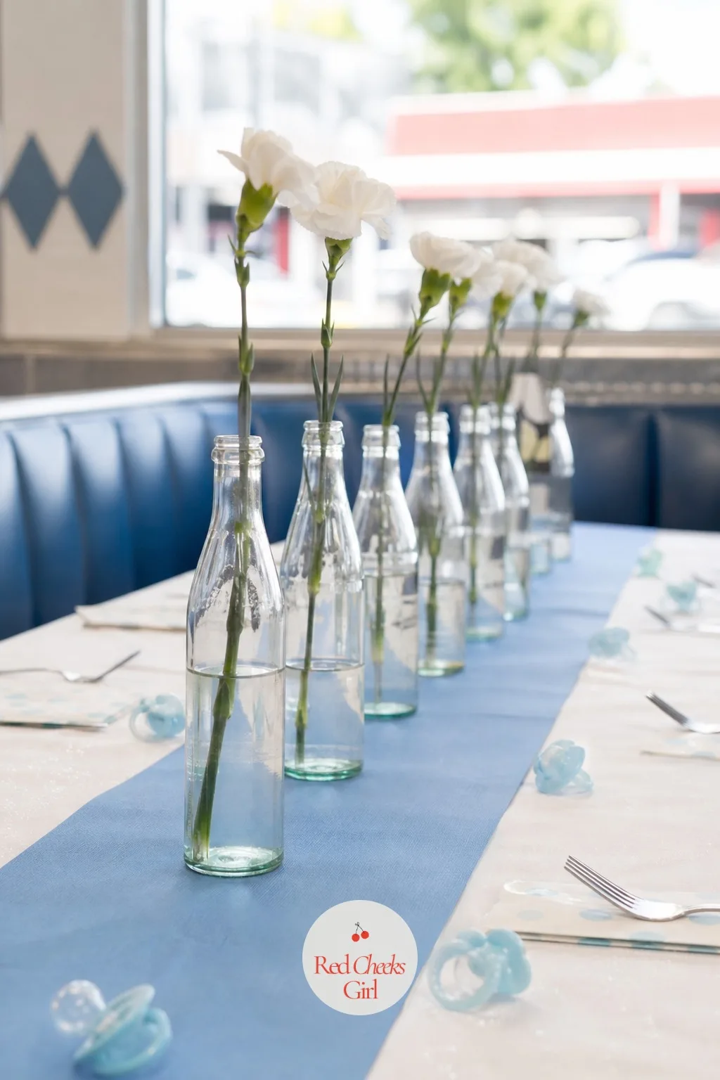 Soda Bottle Bud Vases — A row of identical glass bottles with a single bloom in each looks fussed over without costing anything near what it seems to. Coed