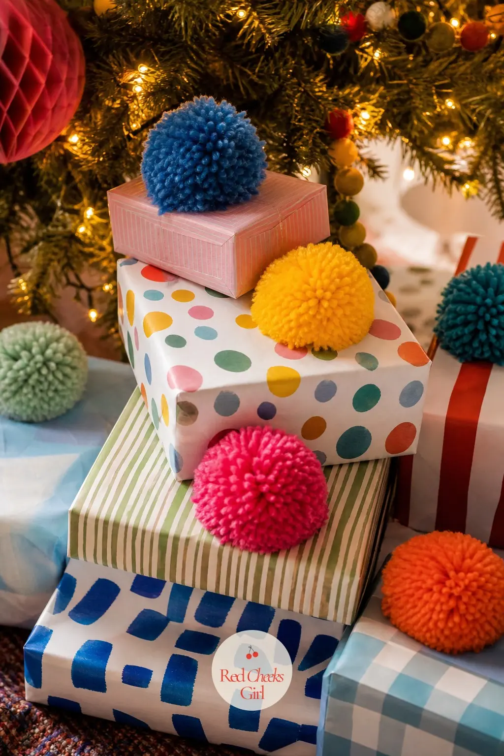 The Stack of Presents, Finished With Pom-Pom Toppers — Under the tree, every wrapped box gets one oversized pom-pom tied on top instead of a bow, in whatever