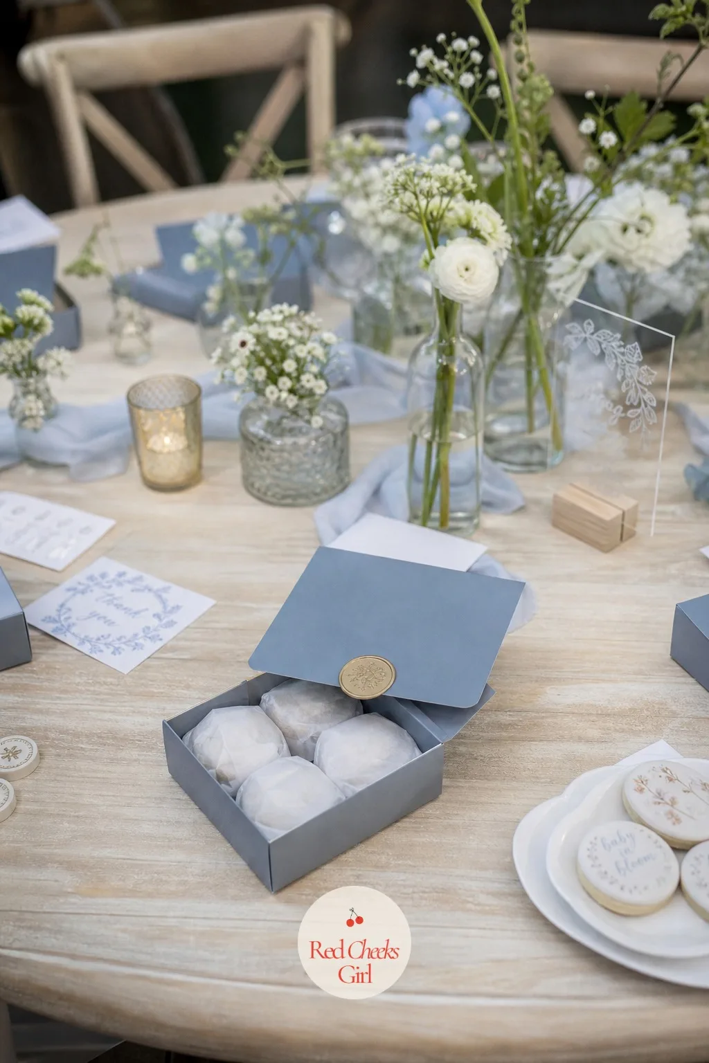 Seasonal Mini Cookie Boxes — A small square box in dusty blue sits half open, four cookies inside wrapped in tissue, held shut by a round wax seal sticker on