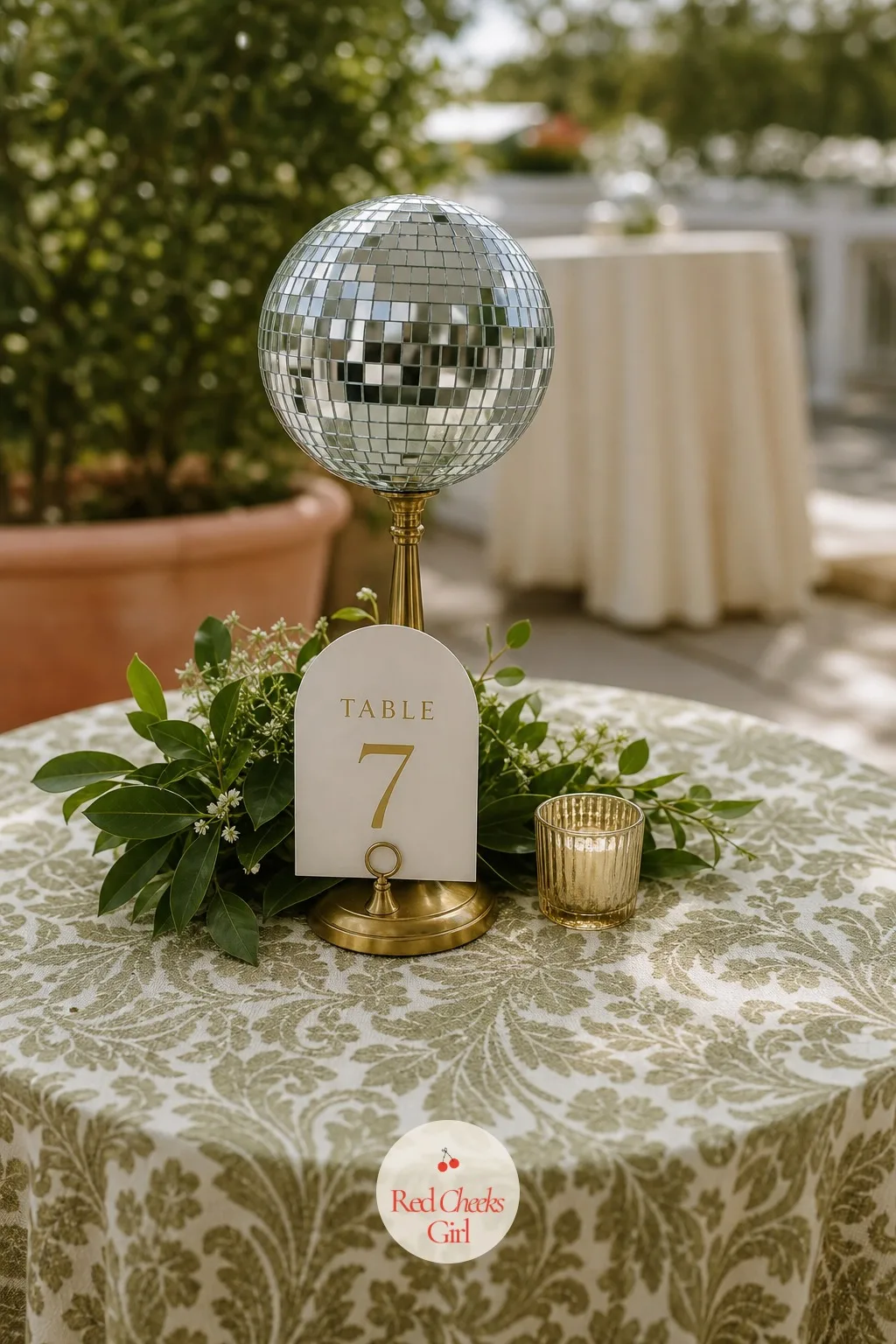Disco Ball Table Numbers — Each cocktail table carries its number not on a card stand but hung right off a small mirror ball sitting at its center, so even the