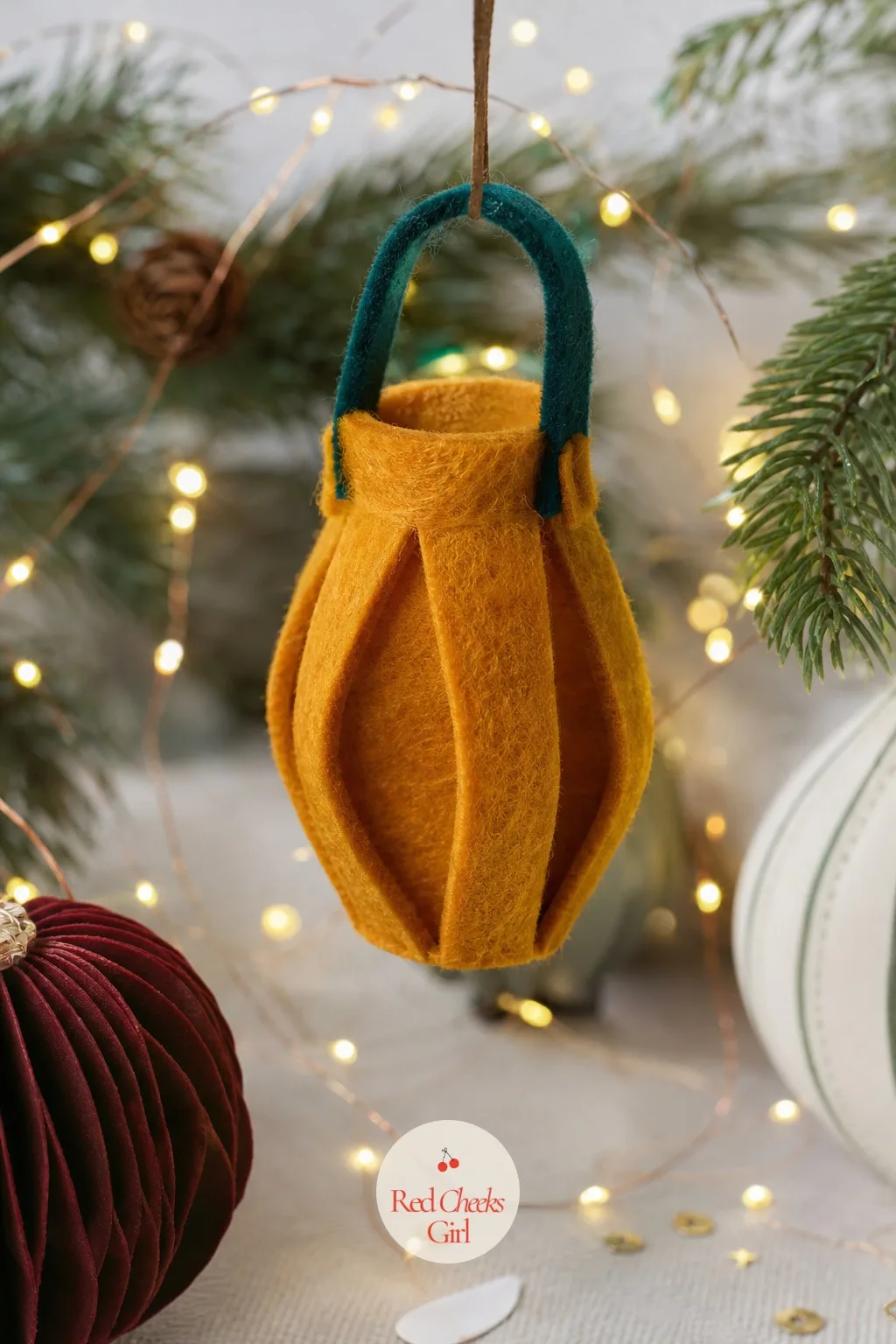 Folded Felt Lantern — This is the ornament that actually catches the tree lights rather than just sitting there looking flat, because the folded sides give it