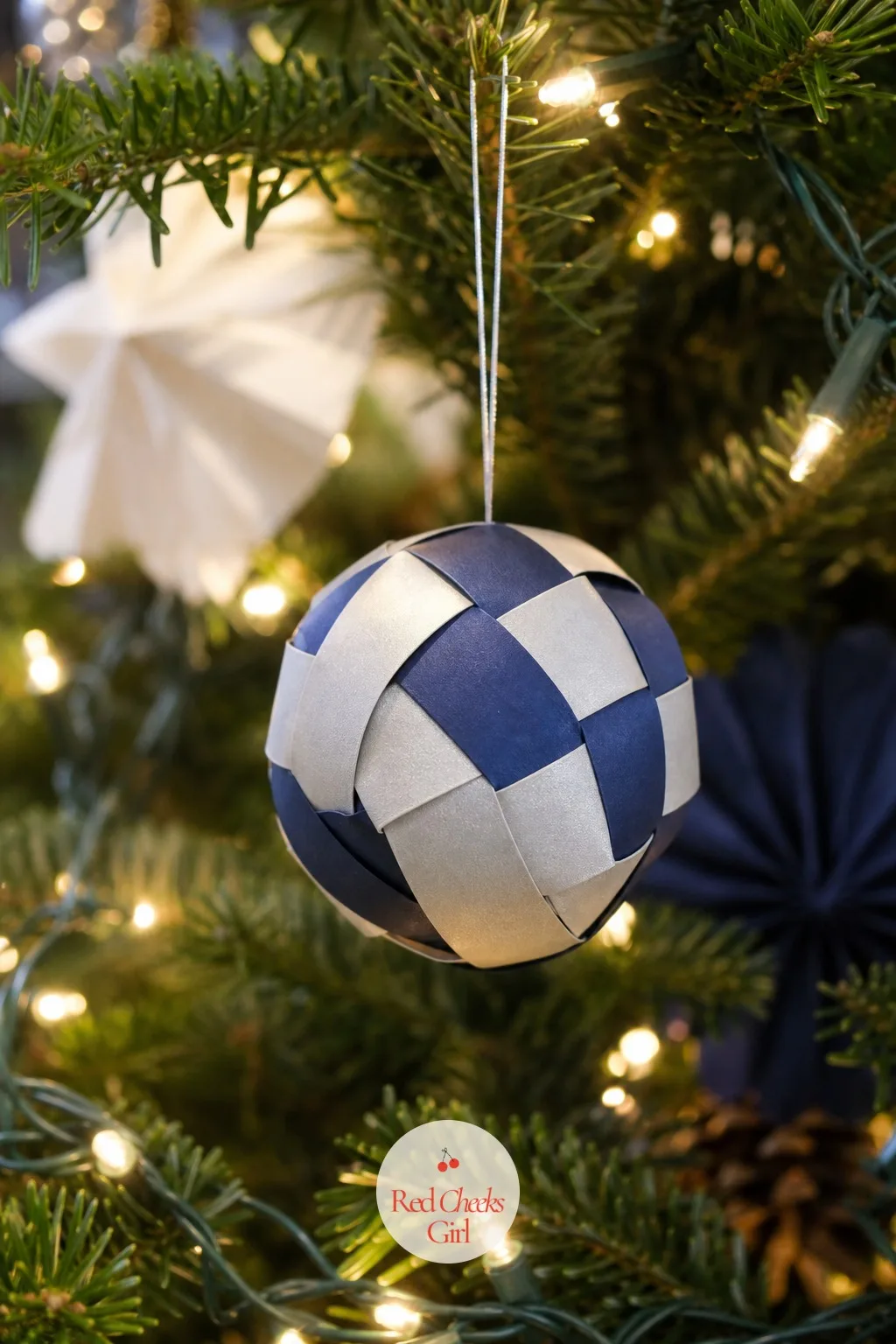 Navy And Silver Woven Ball — Strips of paper, woven over a simple frame of their own folds, build a sphere that looks basket woven rather than papercraft. Diy