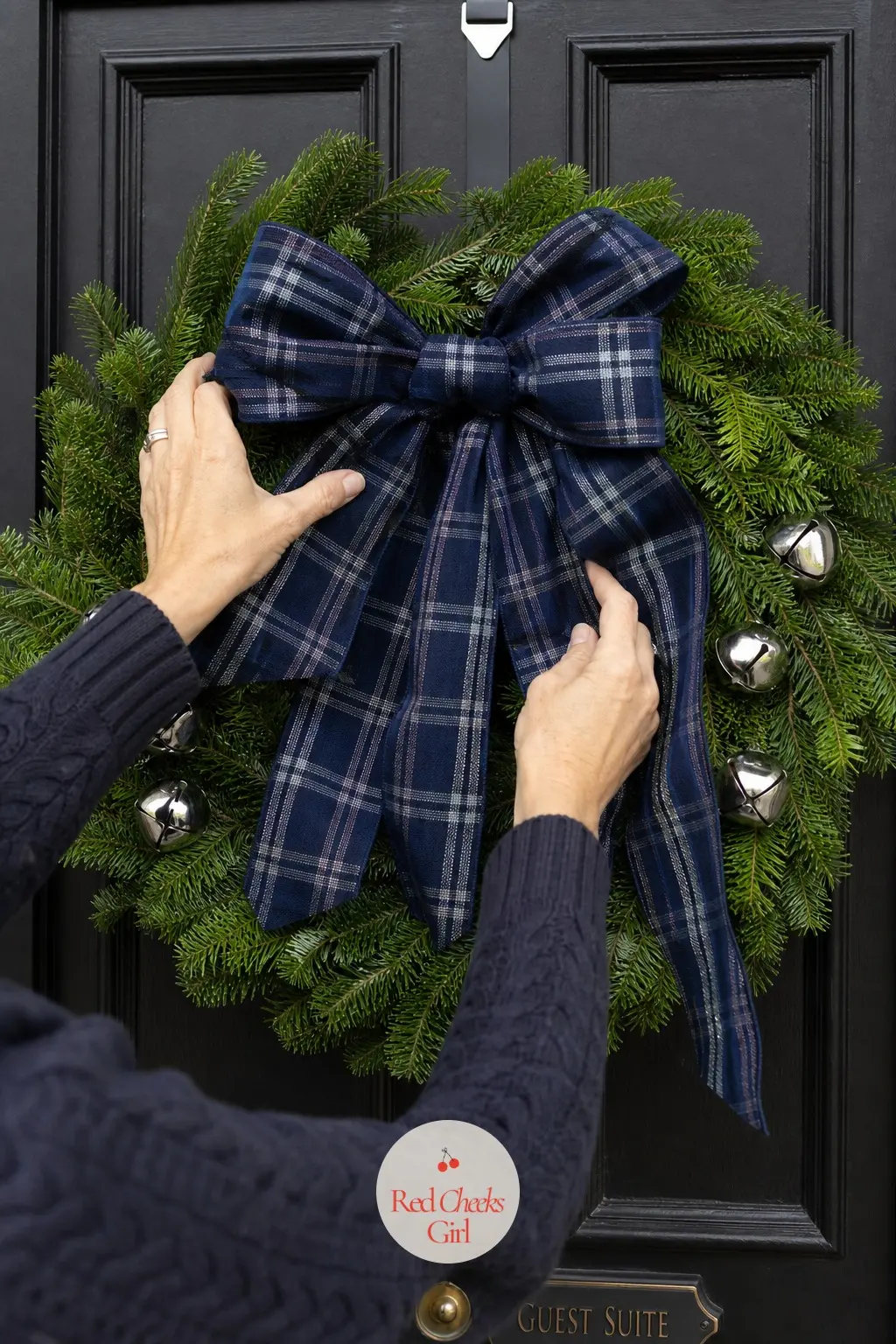 The Navy and Silver Tartan Wreath for the Guest Suite Door — Navy tartan ribbon against a plain green base, with a few small silver bells, suits a guest room