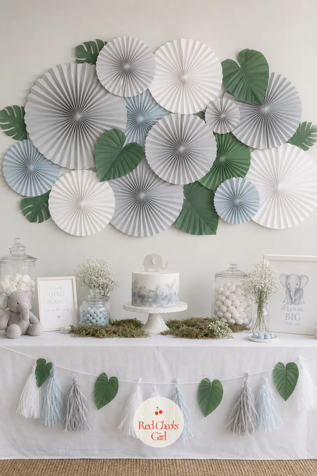 The Elephant Ear Paper Fan Backdrop — A flat wall behind the dessert table looks unfinished faster than anything else in the room. Elephant baby shower theme