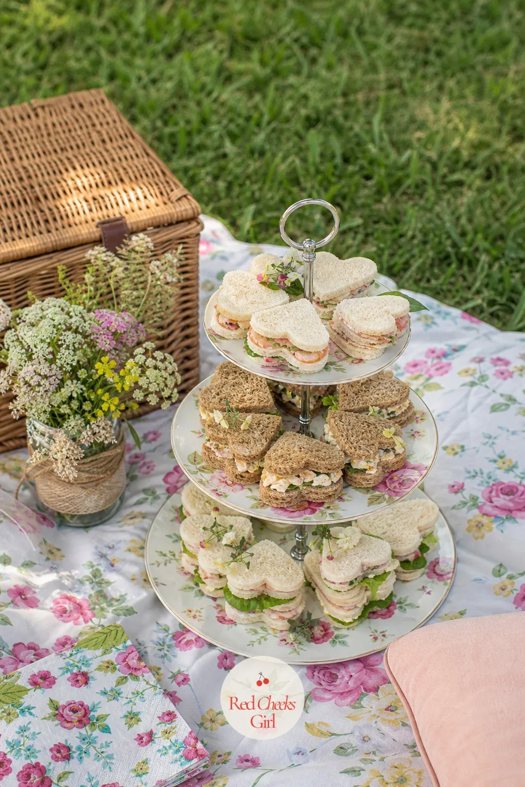 Picnic With Heart Sandwiches — A picnic keeps the whole afternoon low stakes, blanket down, basket open, nobody assigned a seat. Engagement party ideas