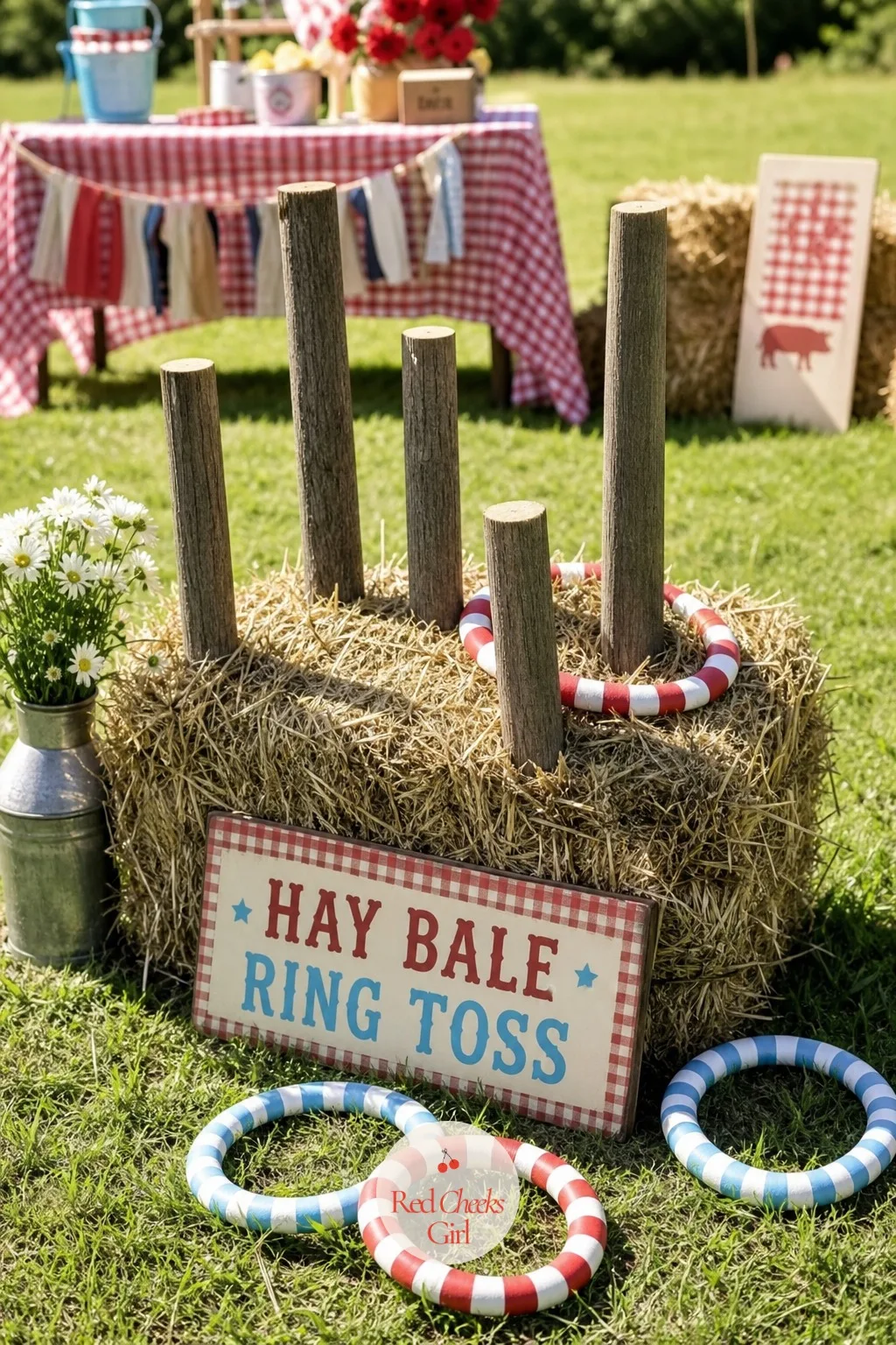 Hay Bale Ring Toss Onto Fence Posts — Short wooden fence posts rise straight out of the top of a hay bale, numbered loosely from one to five, with soft rope or