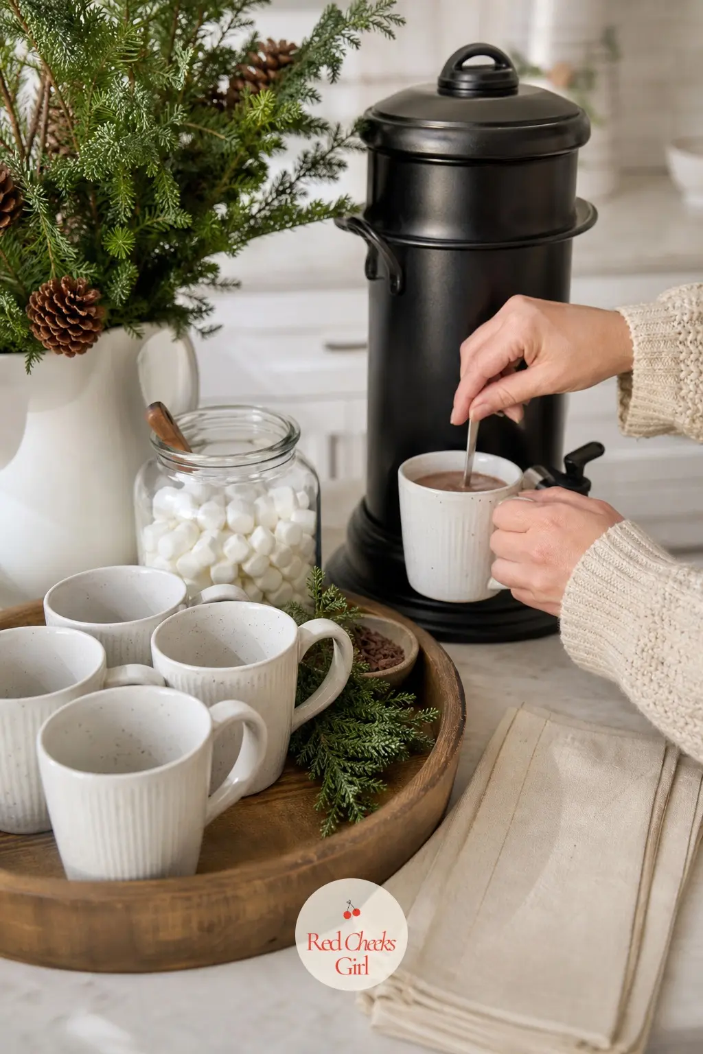 The Hot Cocoa and Coffee Station — A hot drinks station on the counter earns its keep every single morning of the season: white stoneware mugs lined up, a