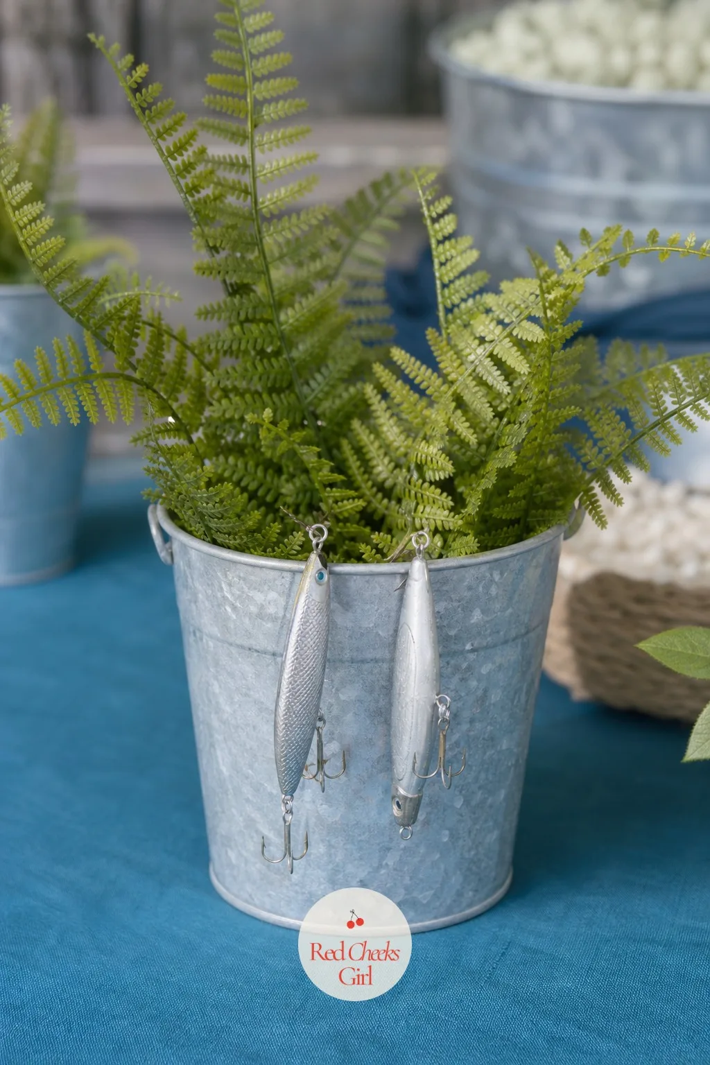 Galvanized Buckets Filled with Lures and Greenery — A centerpiece that tries too hard looks out of place next to shrimp cocktail and fish tacos. Fishing baby