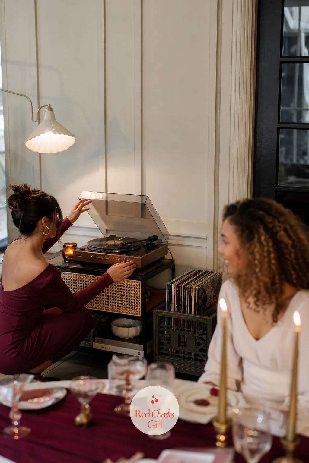 The Record Player Corner — Against one wall, away from the table but close enough to hear, a record player sits on a low shelf with a short stack of vinyl