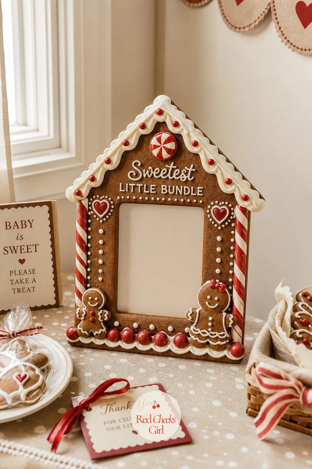 Gingerbread House Photo Frame — A freestanding frame built or rented to look like the front of a small gingerbread house stands in a corner, roofline iced in