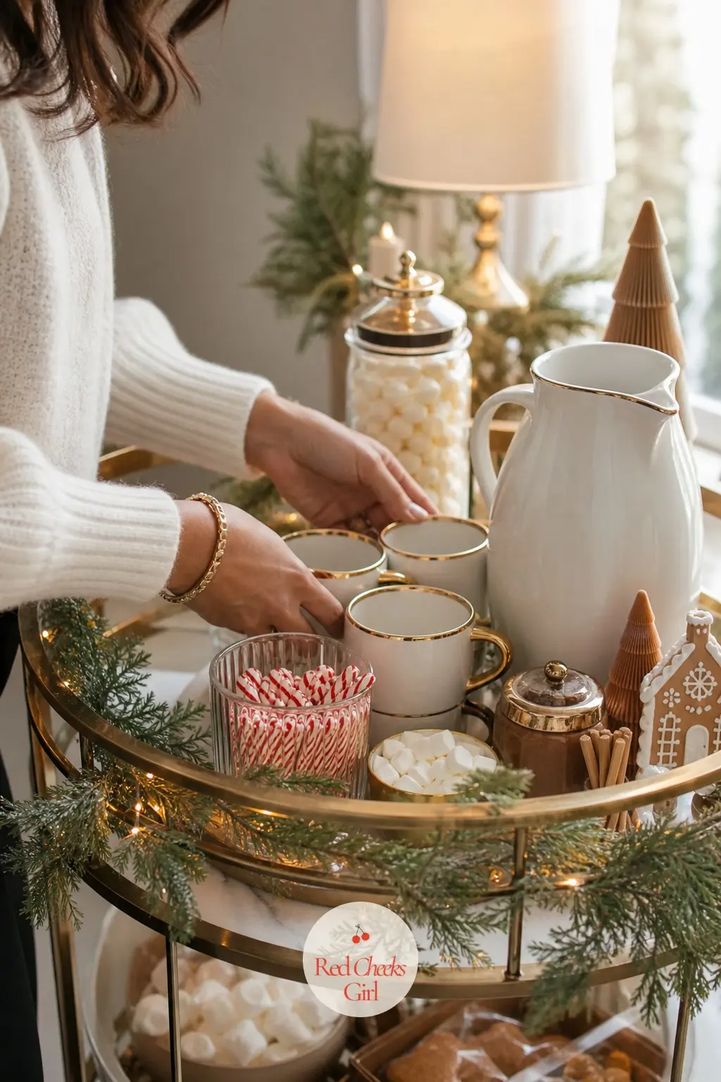A Cocoa Station With Peppermint and Gold — Set a small bar cart or tray with a jug of cocoa, a jar of peppermint stirrers, and mugs in icing white rimmed with