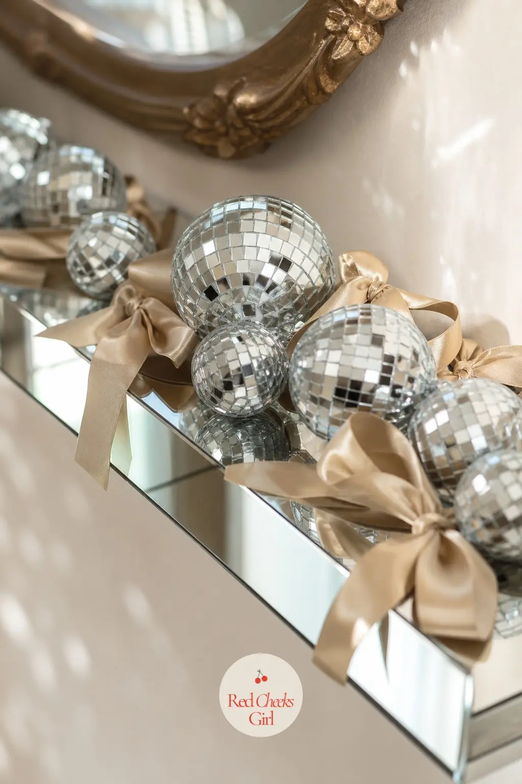 The Gallery Ledge, Dressed With Mini Disco Balls — A narrow mirrored floating shelf holds a loose cluster of mini disco ball ornaments, grouped by size rather