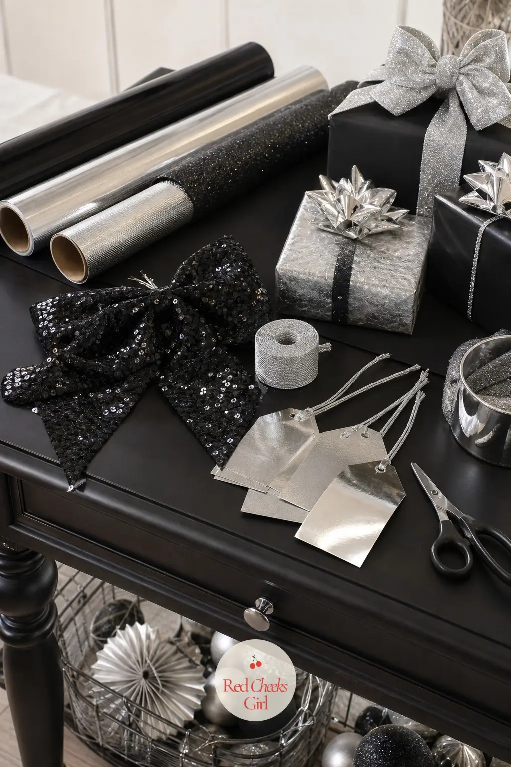 The Gift Wrap Table, Finished in Black and Silver — Two rolls of black wrapping paper sit beside one roll of silver metallic, the only two finishes used on