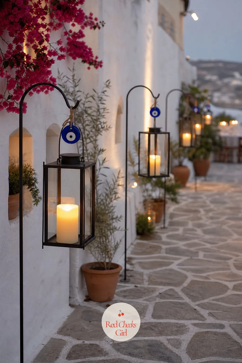 Evil-Eye Lantern Pathway — Guests arrive before the light fades, and a lit pathway tells them where to walk without a single word. Greek wedding