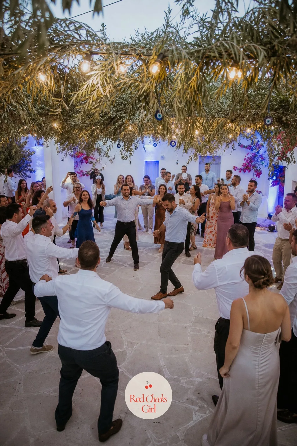 Zeibekiko Dance Circle — The dance floor is where the whole family ends up, so it earns the same decoration as the ceremony arch, just reworked for night.
