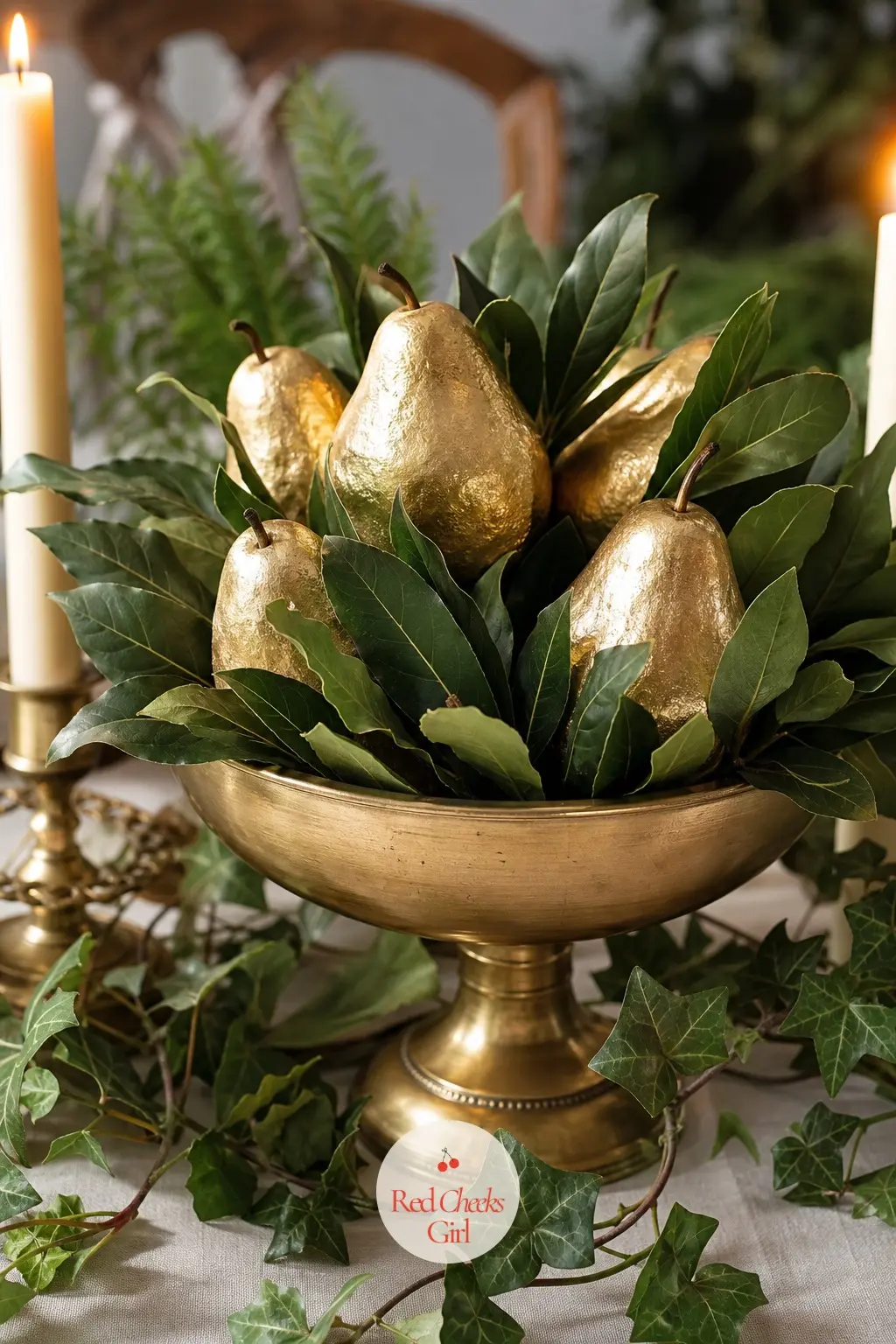 The Centrepiece, Clustered in Bay Leaves and Gold-Dipped Pears — A low brass compote filled with fresh bay leaves and a handful of gold-dipped faux pears sits