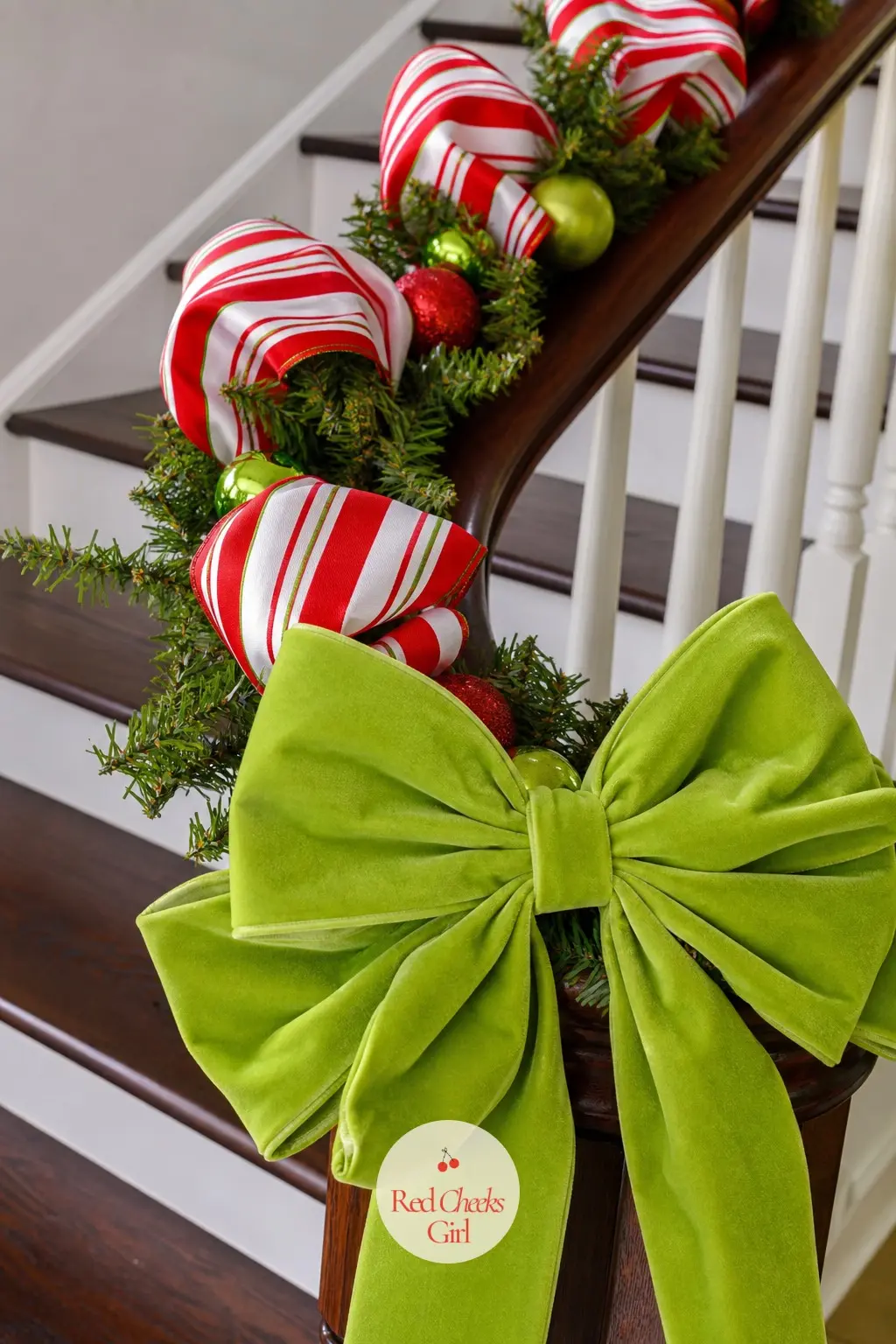 A Candy-Striped Ribbon Swirling Up the Banister — Fresh or faux garland along the rail with a length of wide candy-stripe ribbon woven through it in loose