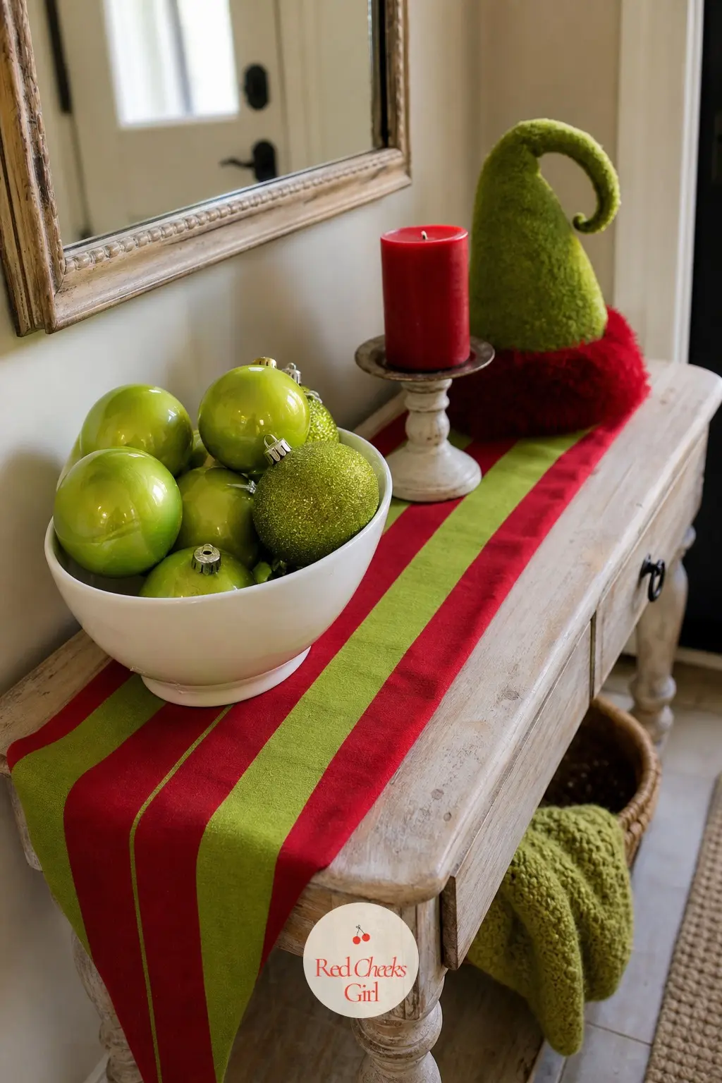 The Entry Table Gone a Little Crooked — A console or bench just inside the door, dressed with a striped runner, a bowl of oversized lime ornaments and one