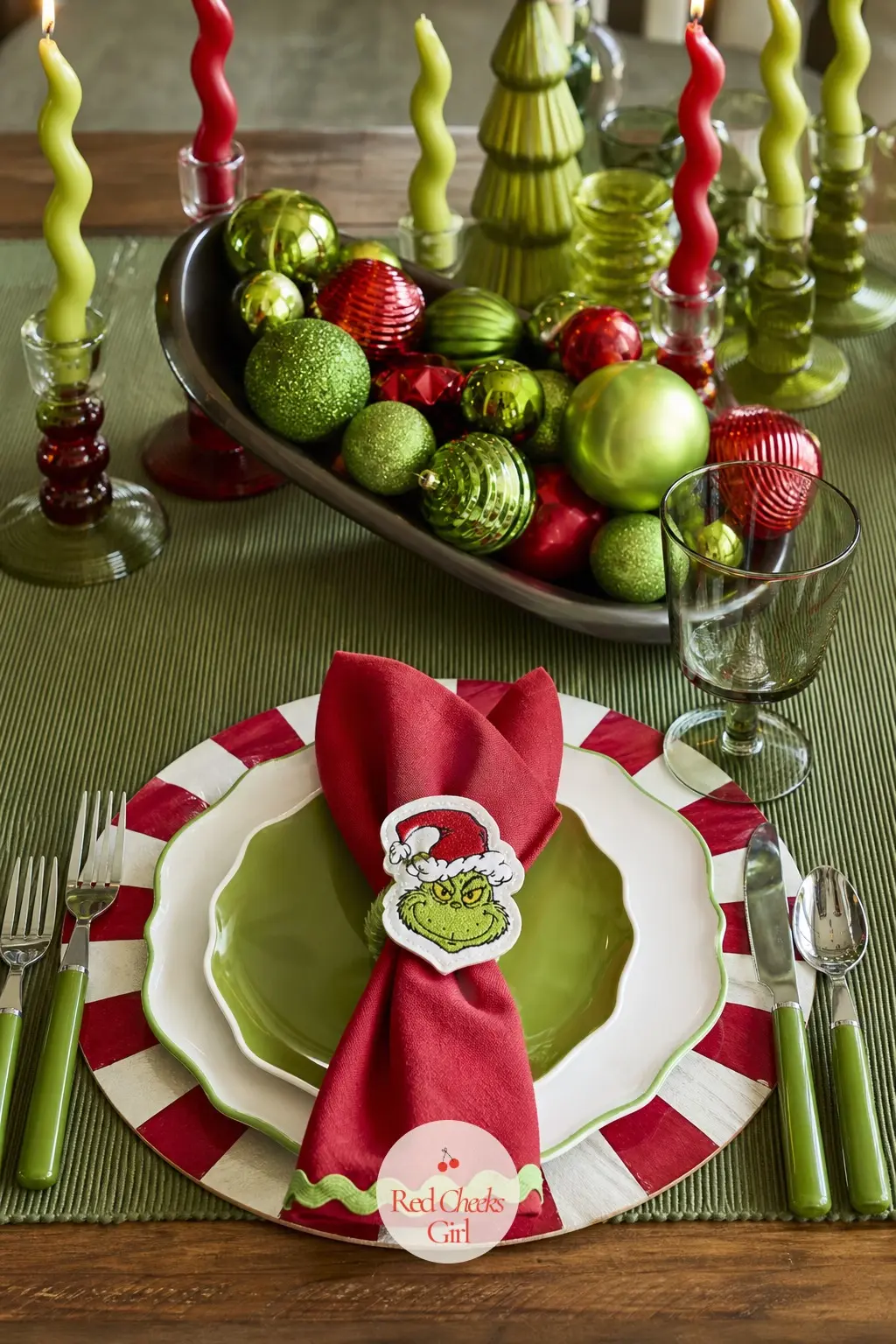 One Place Setting and a Centrepiece That Tips Sideways — A striped charger under each plate, a centrepiece bowl of oversized lime and cherry ornaments piled