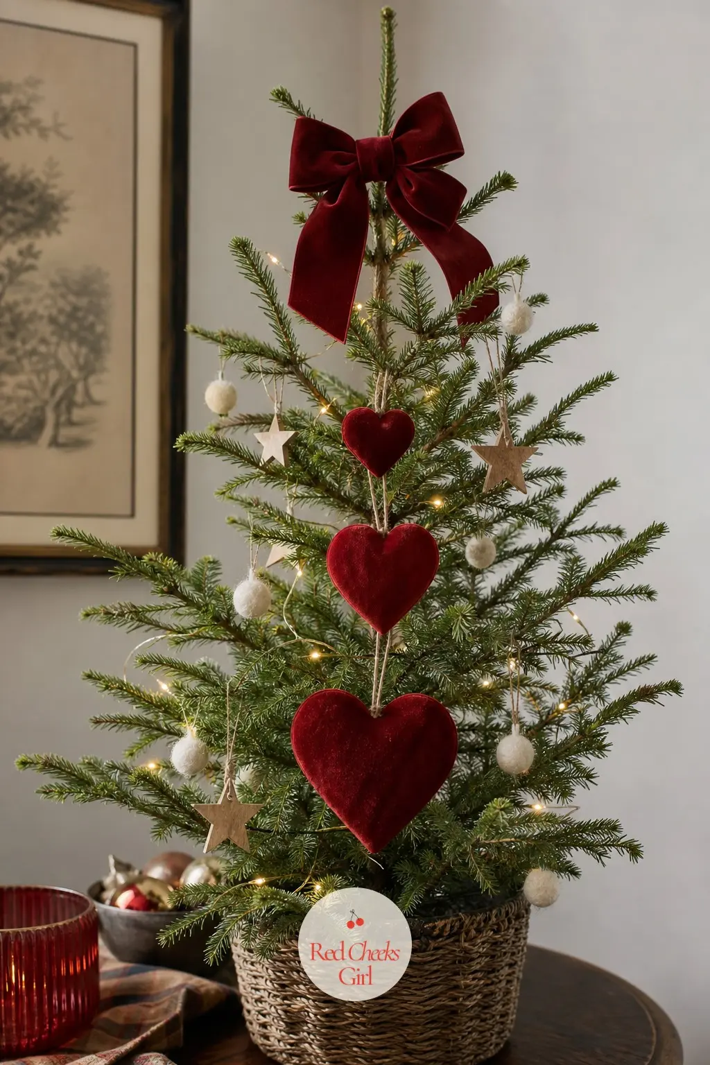 A Sparse Cedar Hung With Three Growing Hearts — A real, deliberately sparse and airy little cedar on a side table, thin enough that every ornament stands alone