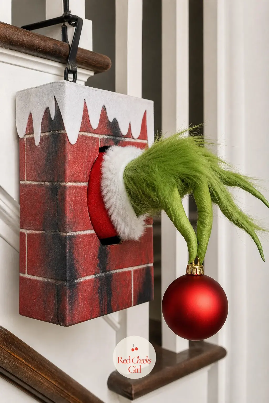 A Grinch Hand Reaching From a Cardboard Chimney Wreath for the Staircase Landing — A candy cane shaped wreath form is the trick here: its curved end already