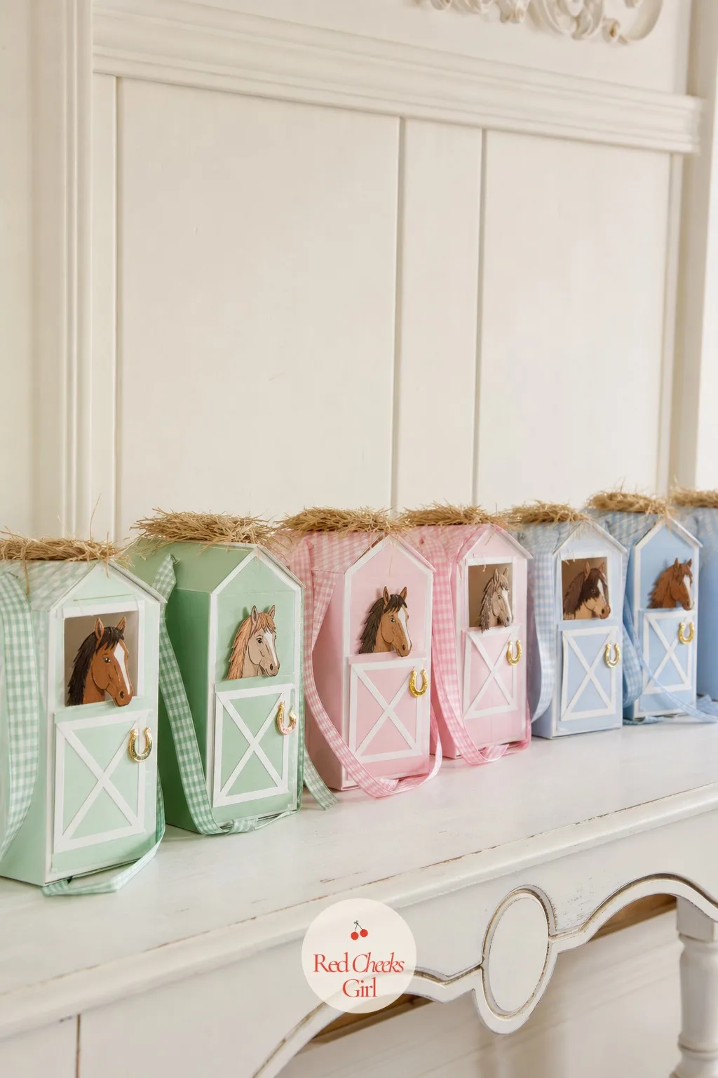 The Favor Box Stable — Line up a row of small stable shaped favour boxes on a shelf or a low table, each with a ribbon handle and a tuft of hay peeking from