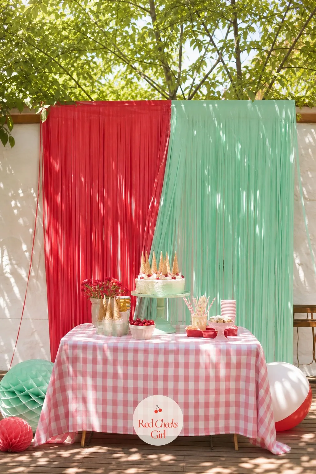 A Fringe Curtain Backdrop In Cherry Red And Mint — If a full balloon wall feels like too much rigging for one afternoon, a fringe curtain does the same work