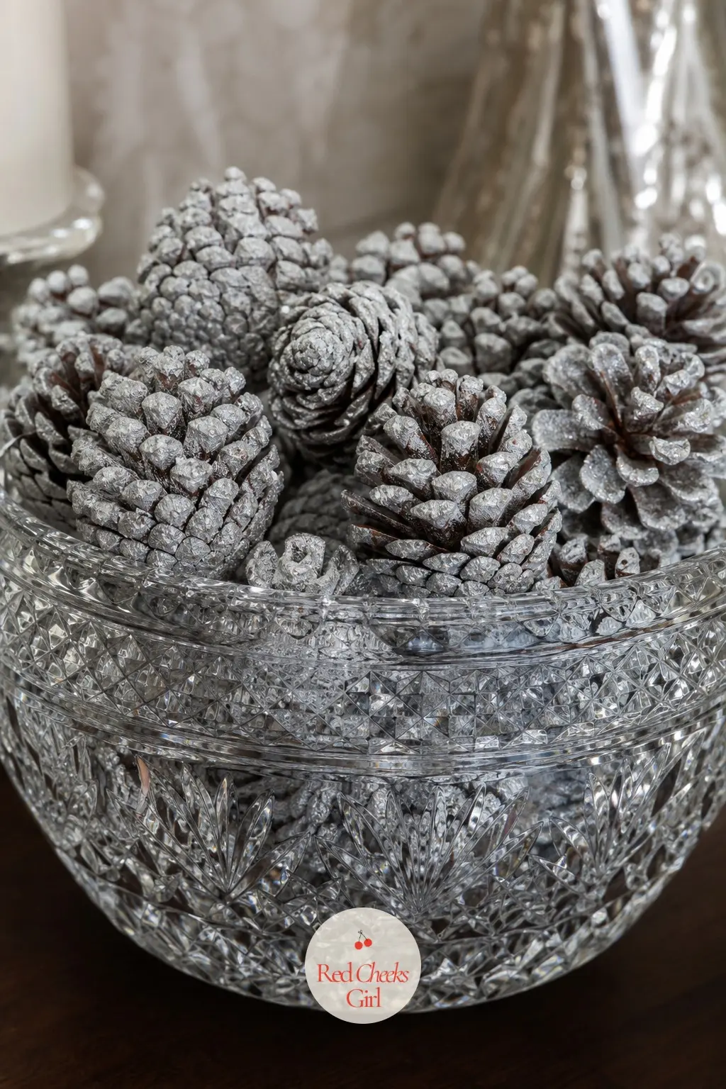 A Cut Crystal Bowl of Frosted Pinecones on the Console — A heavy cut crystal bowl, the kind that sat untouched in a cabinet since a wedding, finally earns its