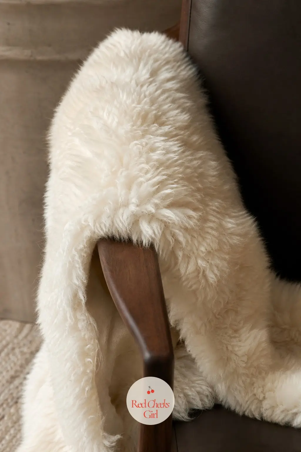 A Faux Sheepskin Draped Over the Arm of the Reading Chair — One ivory faux sheepskin, draped loosely over the arm of whatever chair gets used most, does the