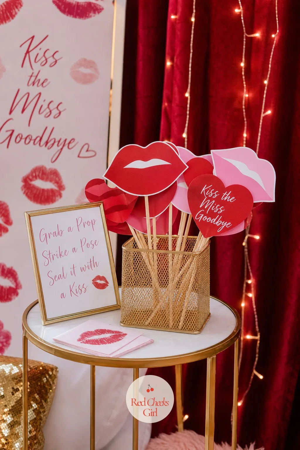 Lip-Print Photo Props — In front of the giant lips backdrop, a small basket of handheld props gives everyone something to do with her hands the moment the
