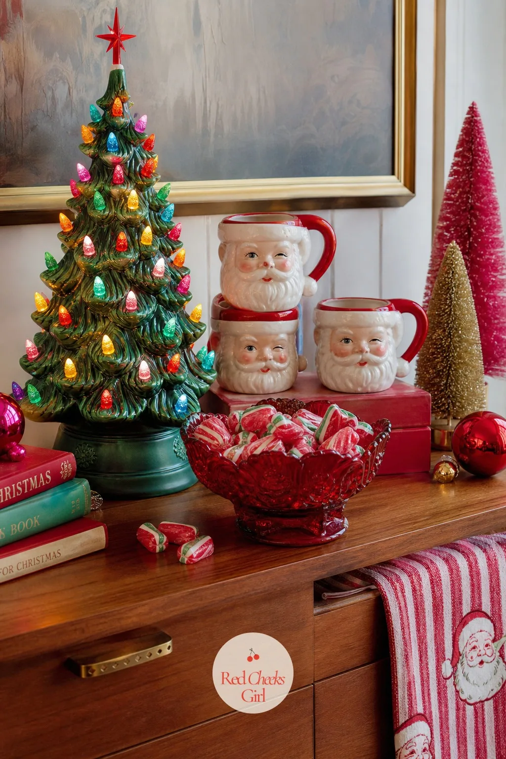Sideboard Scene With a Ceramic Light-Up Tree, Santa Face Mugs and a Cranberry Glass Dish of Ribbon Candy — This is the corner guests actually stand at while
