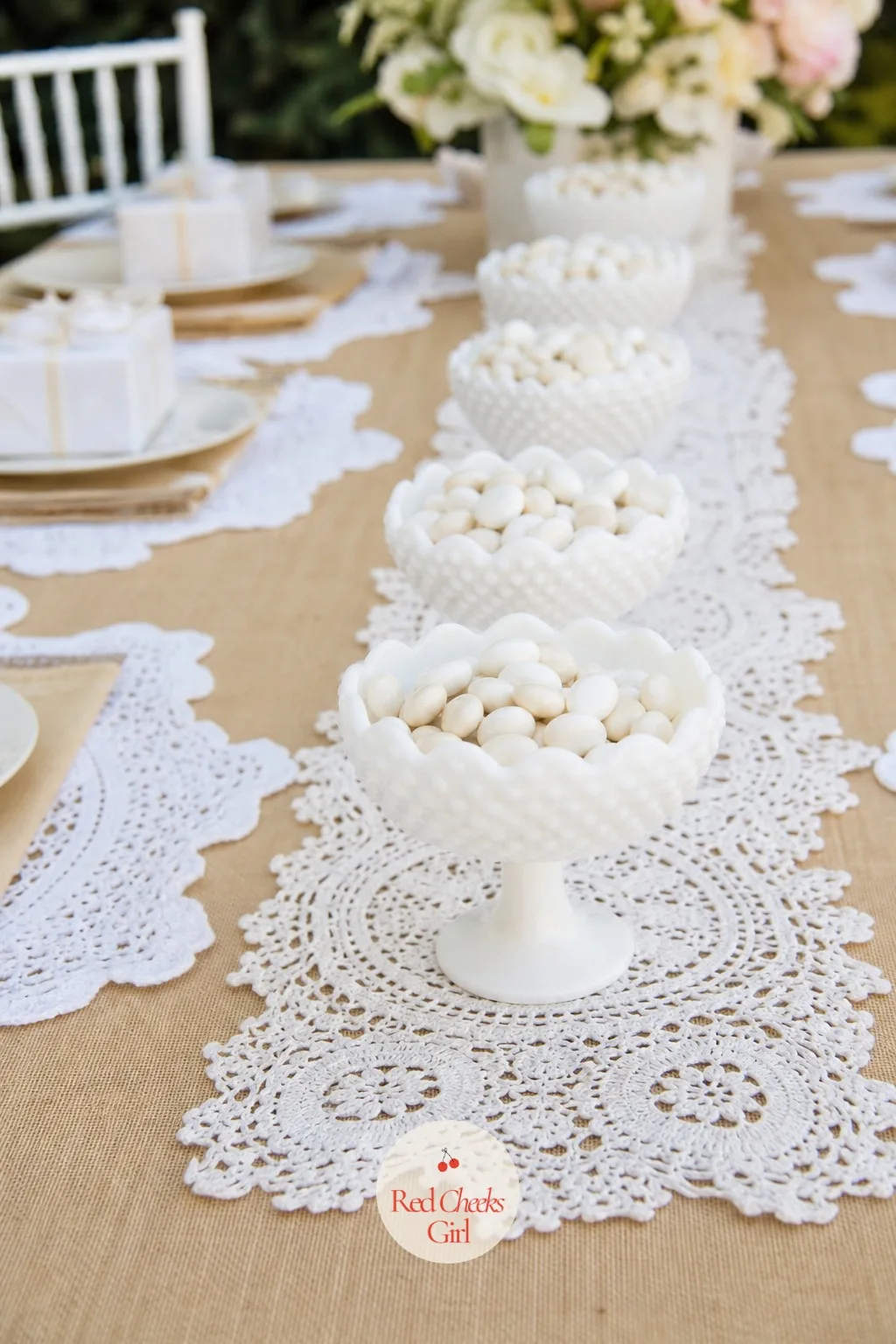 Milk Glass and Doily Centerpiece Runner — A single centerpiece in the middle of a long table can look lonely once guests spread down both sides. Lace baby
