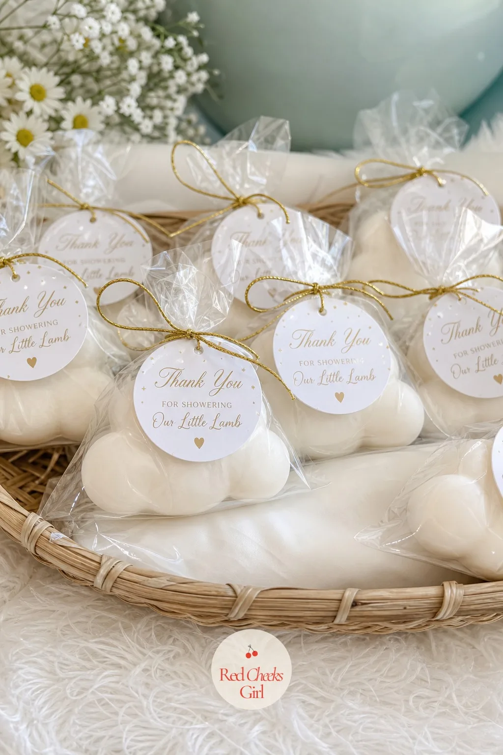 Cloud Soap Favors — Small bars of soap, molded into a soft rounded cloud shape, sit wrapped in clear cellophane and tied off with a short length of gold twine