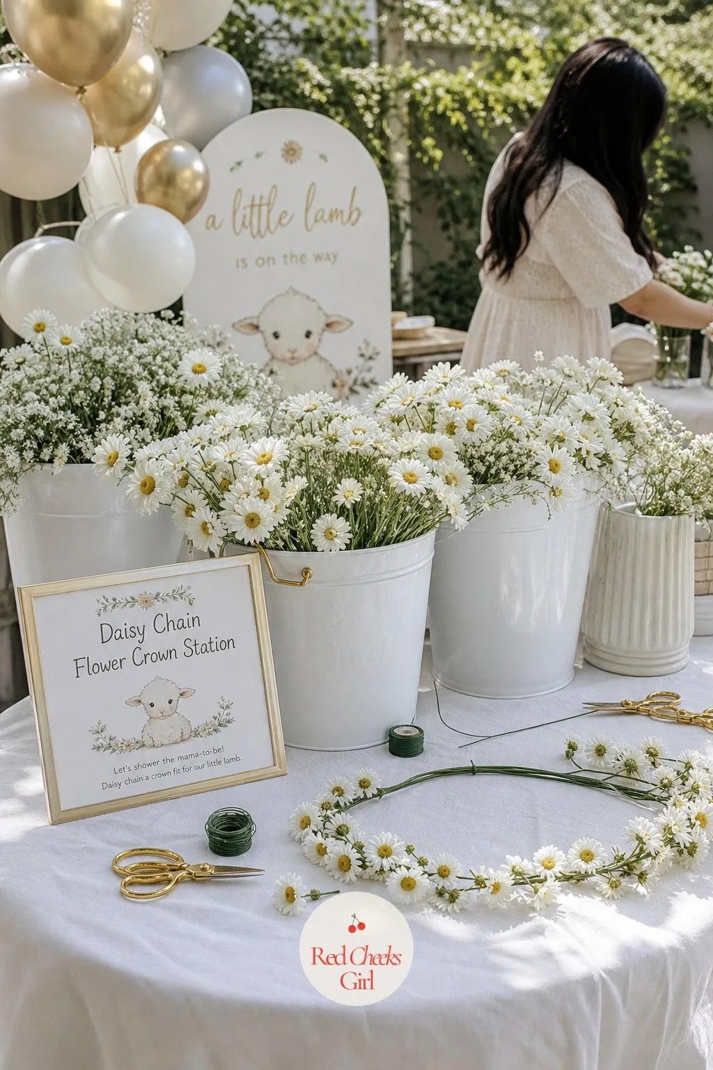 Daisy Chain Flower Crown Station — A low table holds buckets of loose fresh or silk daisies, a spool of thin floral wire and a pair of scissors, set out so