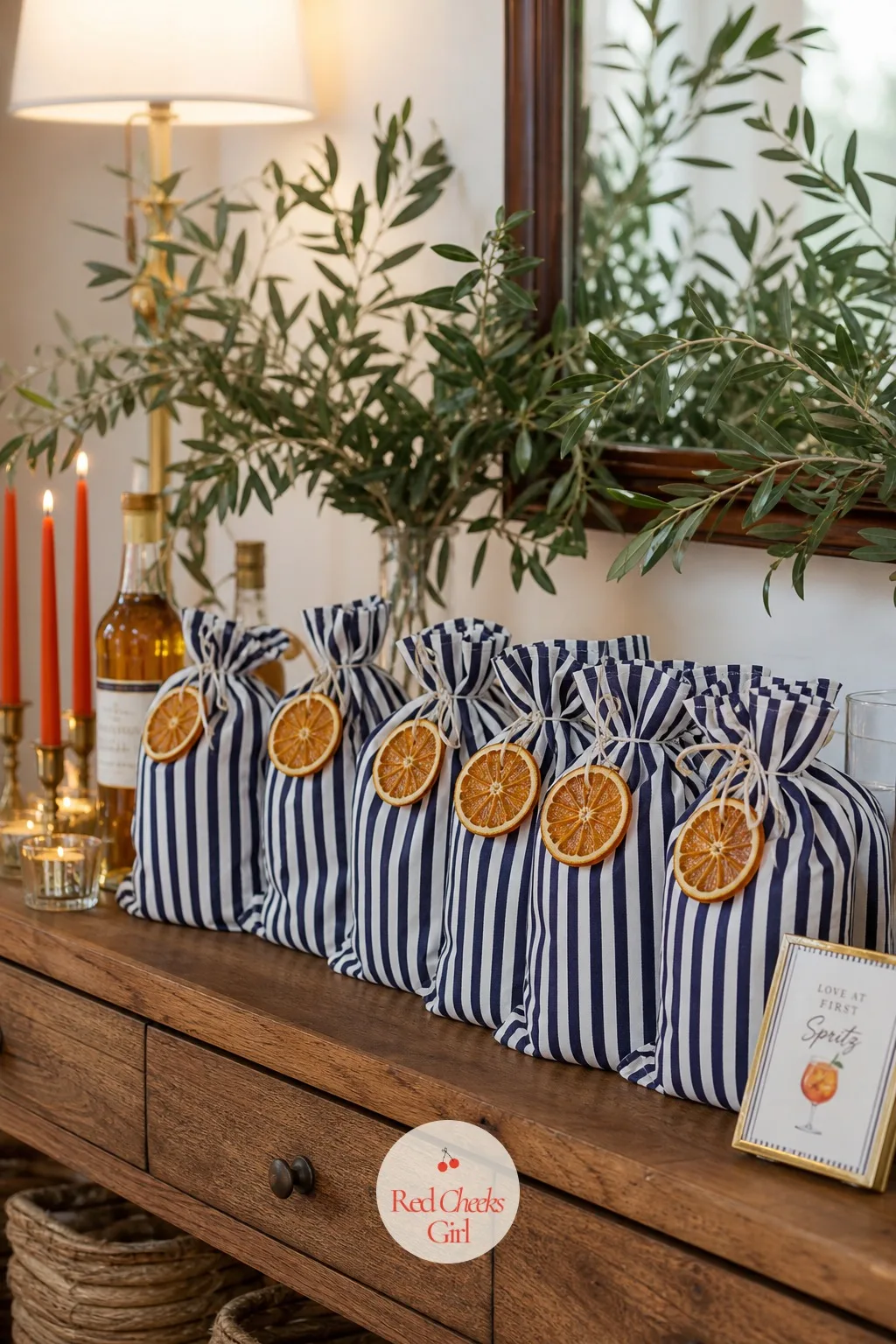 The Striped Favor Bags — Rather than hand guests a loose candle and a bottle separately, this gathers everything into one bag that looks finished the second