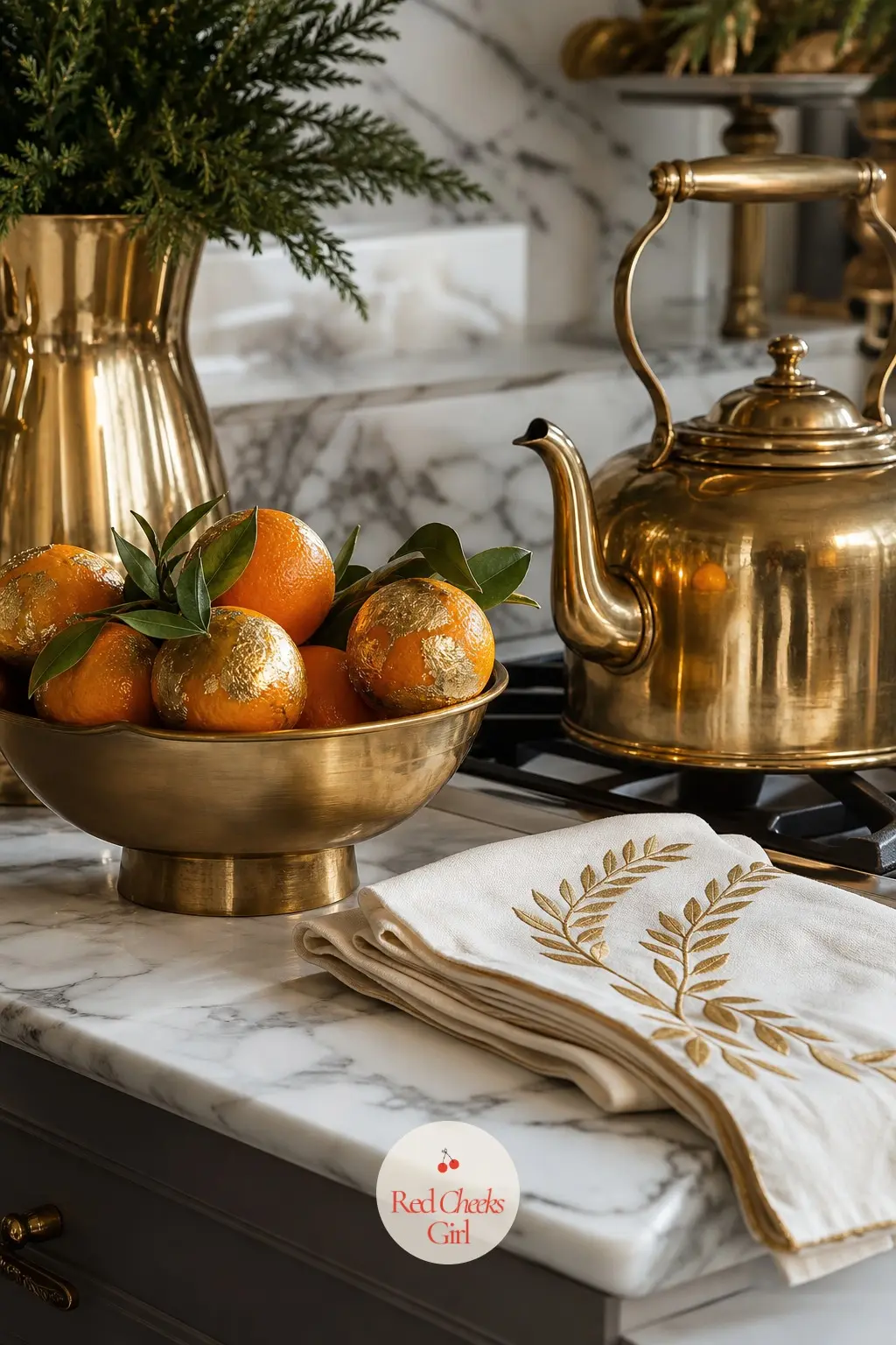 The Kitchen Counter, Kept Hotel Neat — Only what earns its place stays out: a brass kettle, a stack of ivory tea towels, and one small bowl of gilded