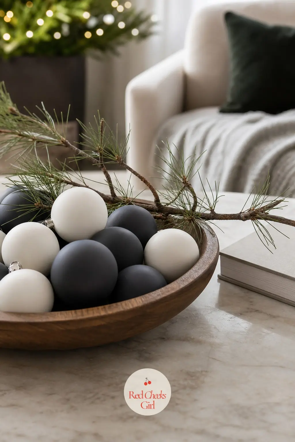 A Coffee Table Styled With Matte Spheres And A Low Branch Bowl — A walnut bowl filled with matte sphere ornaments in graphite and white, one low branch laid