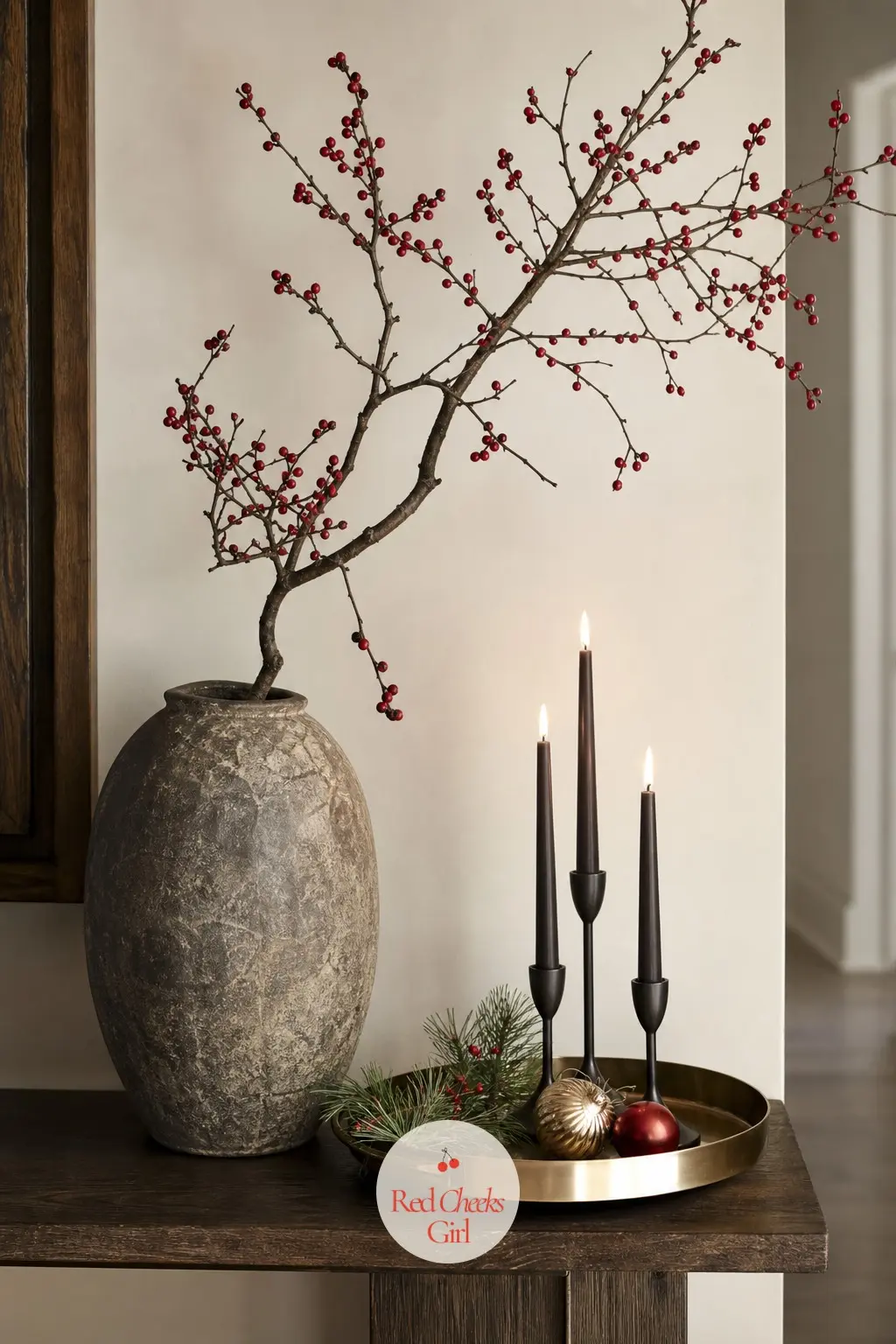 A Console Vignette Built Around One Oversized Branch — Just past the door, a tall stone vase holding one oversized branch anchors the console, with a brass
