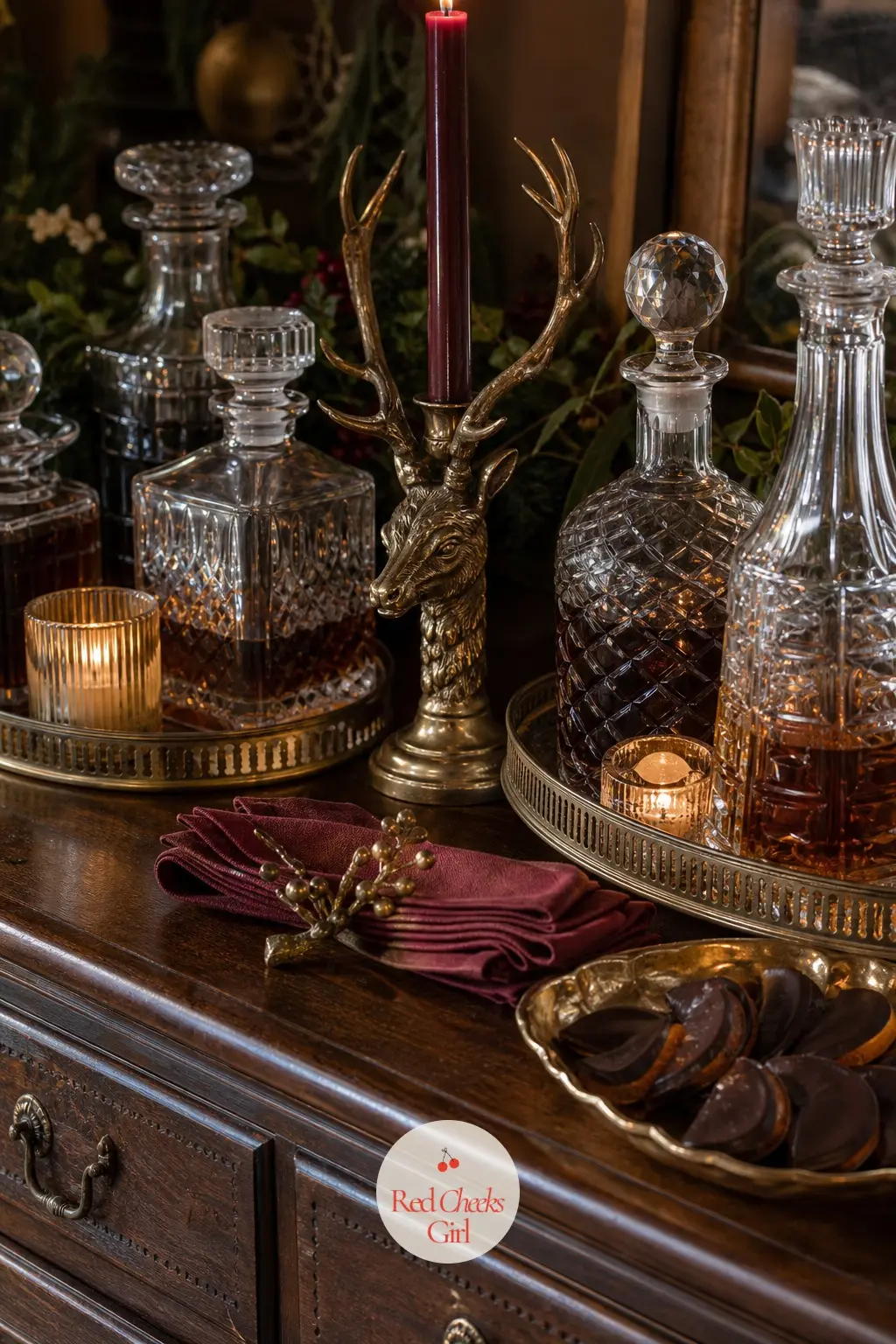 The Sideboard, Set with Brass and Glass — The sideboard behind the table carries the overflow: a cluster of brass trays holding decanters, a stack of extra